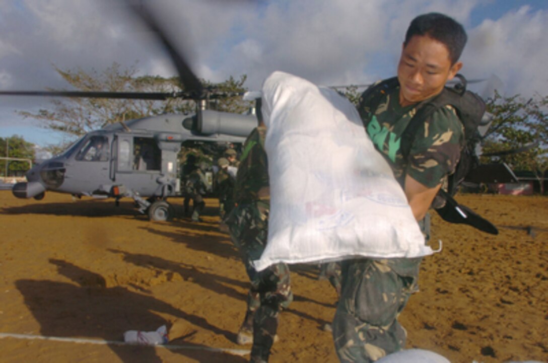 Philippine military personnel unload supplies from a U.S. Air Force HH-60 Pavehawk helicopter during typhoon relief operations in the town of Real in the Quezon Province of the Philippines on Dec. 16, 2004. About 600 U.S. military personnel are in the Philippines providing humanitarian assistance and disaster relief to residents of Quezon Province where widespread flooding and landslides have occurred. U.S. Air Force and Marine helicopters are delivering supplies to the stricken areas. The Pavehawk is assigned to 33rd Rescue Squadron, Kadena Air Base, Japan. 