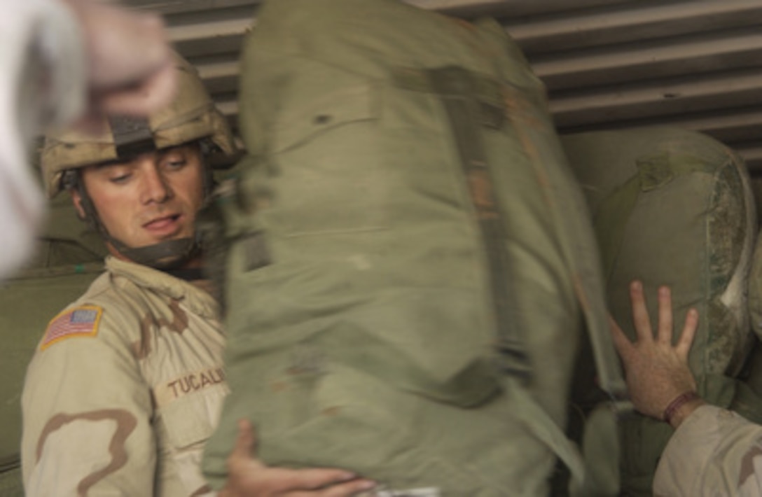 U.S. Army Sgt. Marinn Tucaliuc stacks duffel bags inside a shipping container in Kirkuk, Iraq, on Dec. 13, 2004. Tucaliuc is assigned to Charlie Company, 1st Battalion, 14th Infantry Regiment from Schoffield Barracks, Hawaii. 