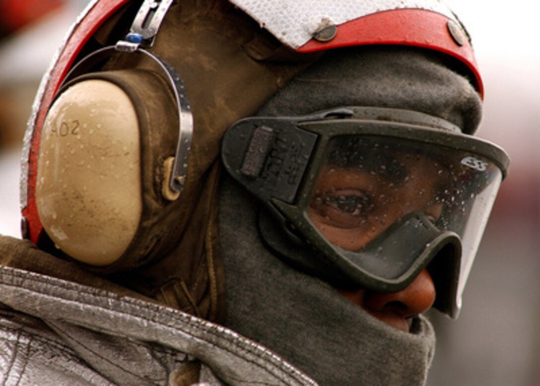 Petty Officer 3rd class Roderick Anderson stands focused despite the elements during flight operations on the flight deck of the aircraft carrier USS Harry S. Truman (CVN 75) in the Persian Gulf on Dec. 1, 2004. Truman and its embarked Carrier Air Wing 3 are providing close air support and conducting intelligence, surveillance and reconnaissance missions over Iraq. Anderson is a Navy aviation boatswain's mate assigned to the Crash and Salvage Team. 