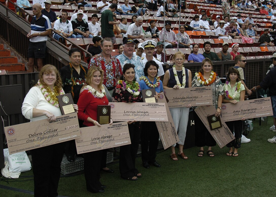 041224-N-0106C-002 PEARL HARBOR, Hawai'i (Dec. 24, 2004) - Spouses representing seven military services in Hawai'i display a check for $1,000 and a plaque from the Honolulu Council of the  Navy League on the sidelines of  the field at Aloha Stadium after the Navy League and other private sponsors from Hawai'i presented the award to the spouses. The seven women were recognized for their contributions to service members at the 50-yard line before the kickoff of the 2004 Aloha Bowl. From left to right, the spouses are Debra Collier representing the Coast Guard,  Lorie Abrego representing the Marine Corps, Lorna Souza representing the Hawai'i Air National Guard, Carrie Takenaka representing the Hawai'i Army National Guard, Jolande Murray representing the Air Force, Sherrie Ingram representing the Navy and Amy Hargrave representing the Army. Behind them (from left to right) are Tennyson Lum, president and CEO of Pioneer Pacific Financial Services - the company who provided the honorarium for the spouses; Kraig Kennedy, president of the Honolulu Council of the Navy League; Bill Bigelow, a member of the Navy League and Rear Adm. Michael C. Vitale, Commander, Navy Region Hawai'i and Commander, Naval Surface Group Middle Pacific.  U.S. Navy photo by Journalist 1st Class Daniel J. Calder-n