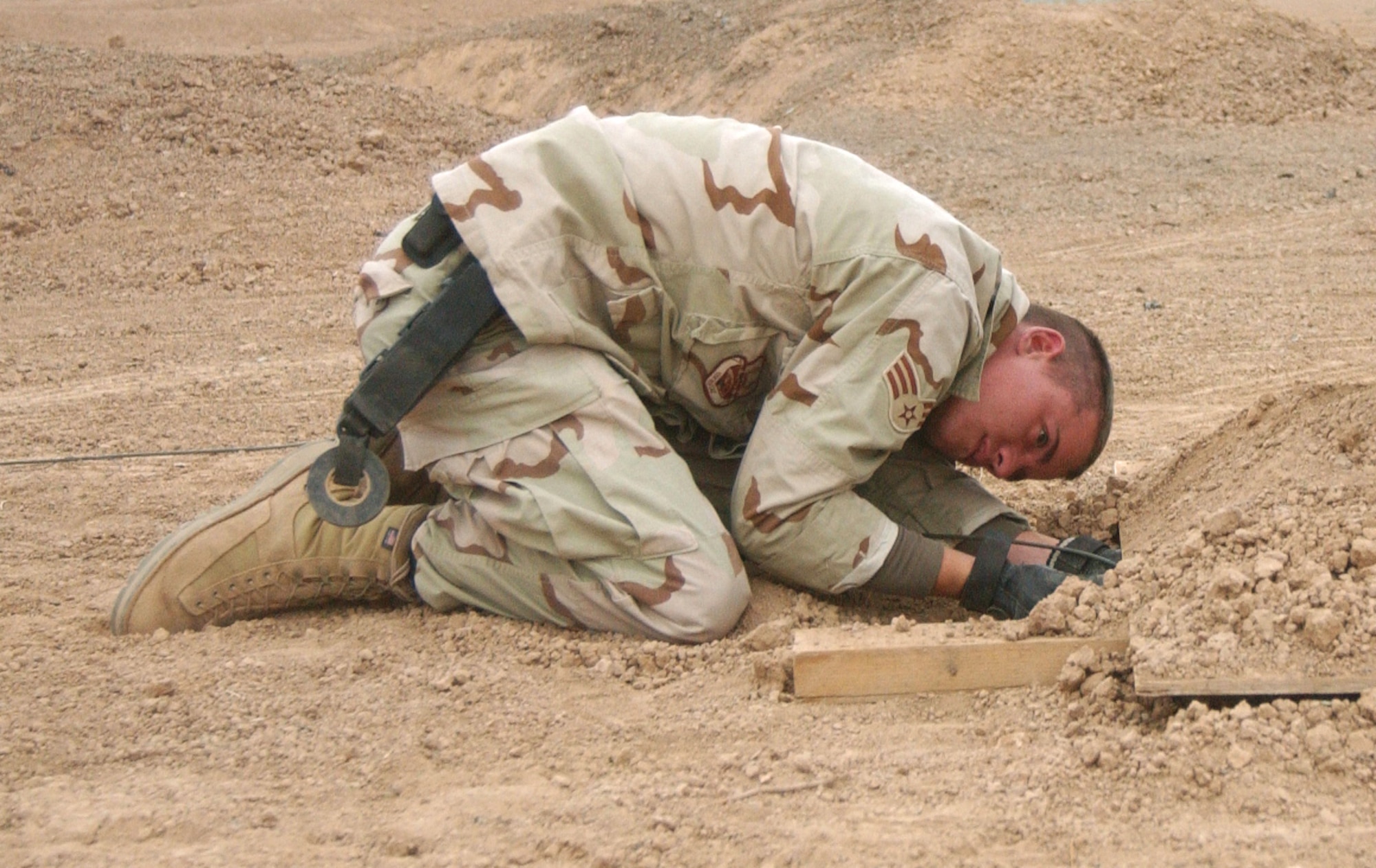 BALAD AIR BASE, IRAQ -- Senior Airman Aaron Johns places a plastic explosive charge under a barrel of contaminated aviation fuel.  Airmen Johns is deployed from Dover Air Force Base, Del.  (U.S. Air Force photo by Staff Sgt. Ryan Hansen)