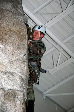 MINOT AIR FORCE BASE, N.D. -- Senior Airman Brandon Helton scales the rock climbing wall during the opening day of Treasure Island here Dec. 23.  Treasure Island is an indoor recreation center featuring a skating park, miniature golf course, batting cages and rock climbing wall.  (U.S. Air Force photo by Airman 1st Class Danny Monahan)