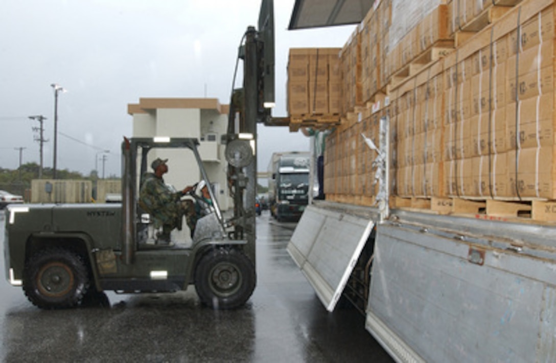 U.S. Air Force Tech. Sgt. Harvey Gilchrist pulls 48 cases of Meals Ready to Eat from a cargo truck before them loading on an aircraft pallet at Kadena Air Base, Japan, on Dec. 28, 2004. The meals will be flown to Southeast Asia as part of disaster relief following an earthquake that caused tsunami waves that affected 12 countries. Gilchrist is assigned to the 18th Services Squadron, 18th Air Wing. 