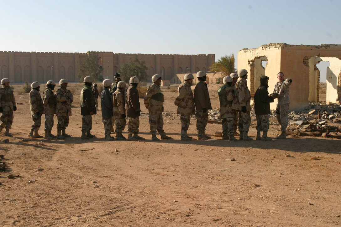 Master Sgt. Michael W. Snow, Explosive Ordnance Disposal chief, Marine Expeditionary Unit Service Support Group 11, 11th MEU (Special Operations Capable), directs Iraqi National Guard soldiers and MEU Marines where to put active rounds during an unexploded ordnance cleanup operation near a 1,200 year-old medieval Persian fort, Dec. 29.