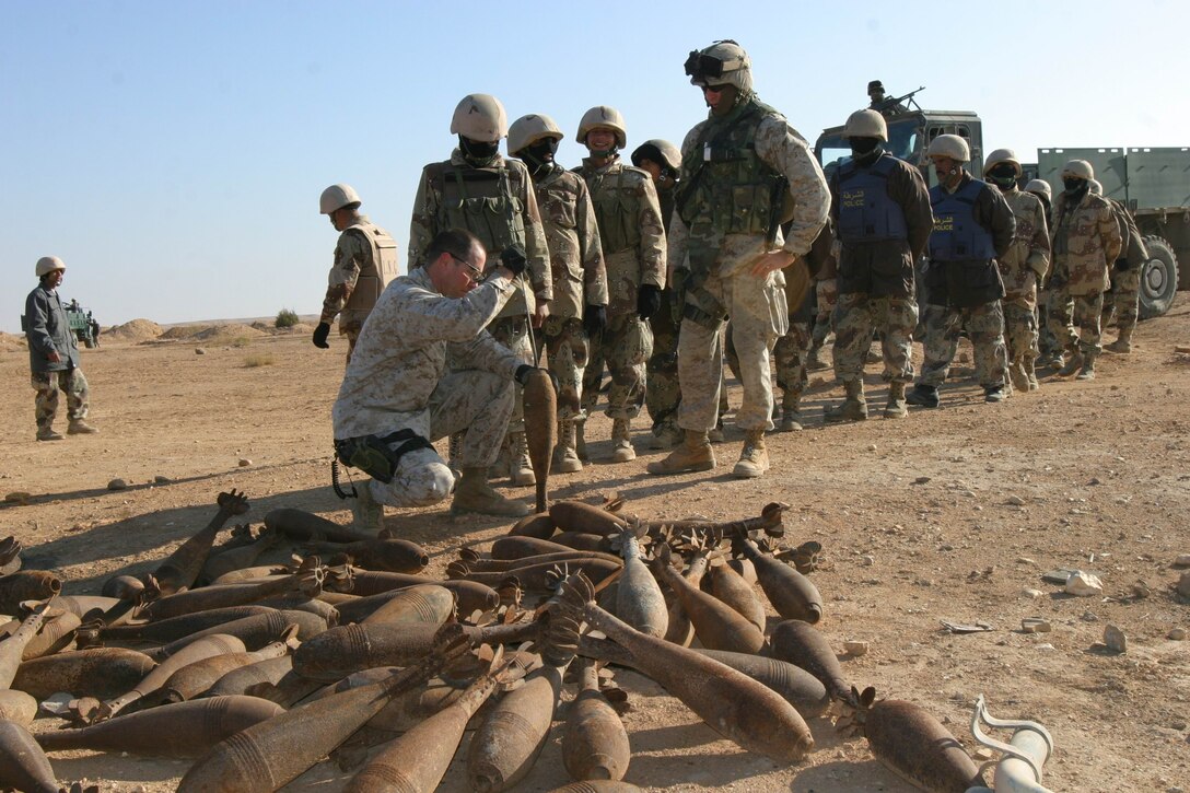 Master Sgt. Michael W. Snow, Explosive Ordnance Disposal chief, Marine Expeditionary Unit Service Support Group 11, 11th MEU (Special Operations Capable), checks a 120 millimeter mortar round for explosive residue during a joint Iraqi National Guard and Marine unexploded ordnance cleanup operation near a 1,200 year-old medieval Persian fort, Dec. 29.