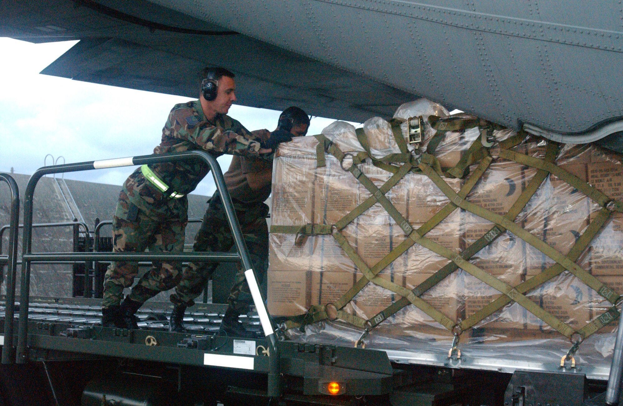 KADENA AIR BASE, Japan  -- Airmen here help load an aircraft pallet of packaged meals bound for Southeast Asia as part of disaster relief following a 9.0-magnitude earthquake that struck Dec. 26 off the coast of Indonesia.  The quake caused tsunami waves that have affected 12 countries and have killed more than 100,000 people.  More than 3,000 cases of meals and four aircraft pallets of fresh water were processed through the cargo area here Dec. 29.  The 18th Wing is providing relief supplies and personnel to help with the humanitarian effort. (U.S. Air Force photo by Tech. Sgt. Richard Freeland)
