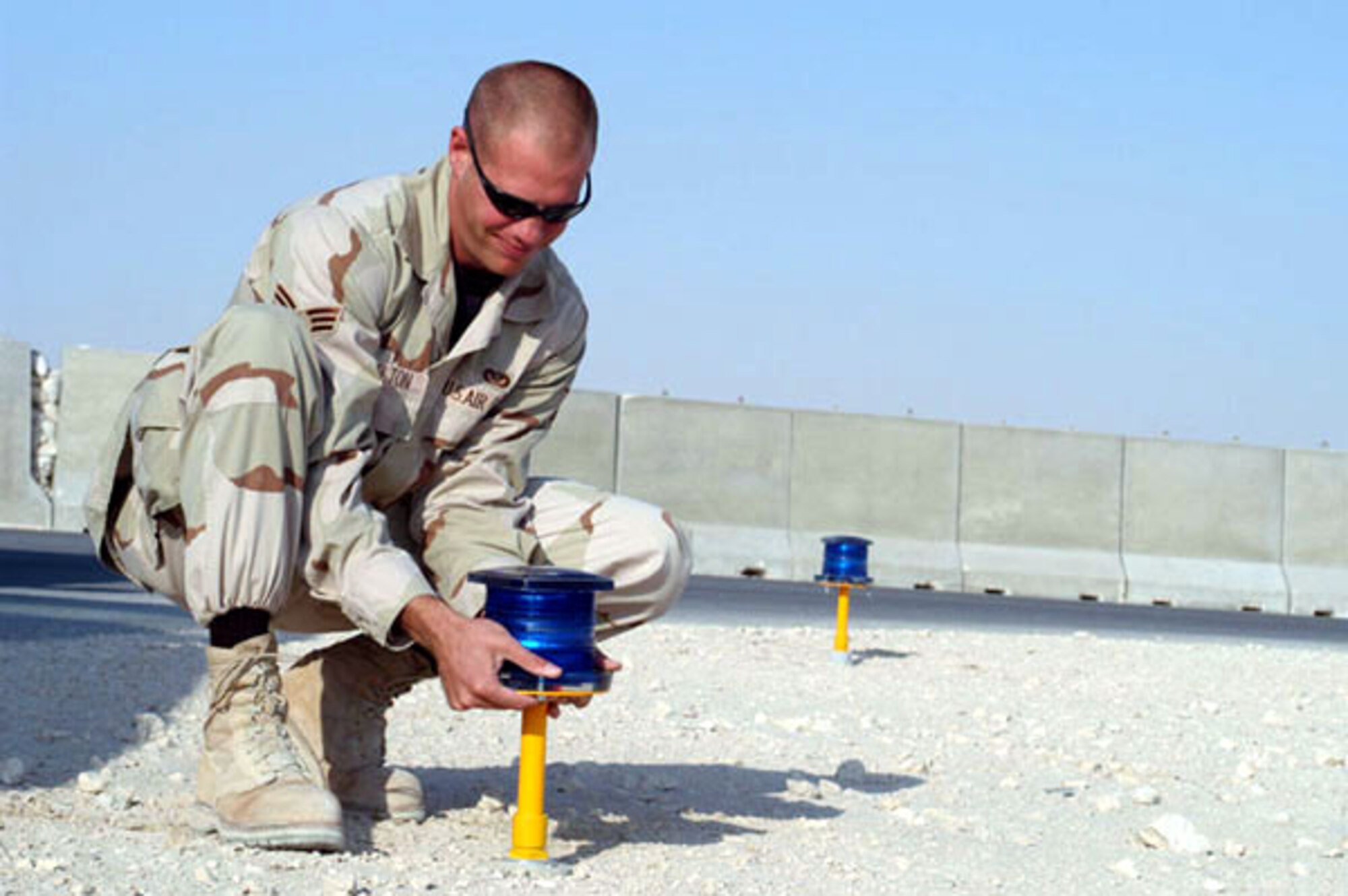 SOUTHWEST ASIA -- Senior Airman Michael Hesselton installs a solar-powered taxiway light at a forward-deployed location.  Airman Hesselton replaced reflectors with the lights, enhancing visibility and safety for aircraft.  He is assigned to the 379th Expeditionary Civil Engineer Squadron.  (U.S. Air Force photo by Senior Airman Lynne Neveu)