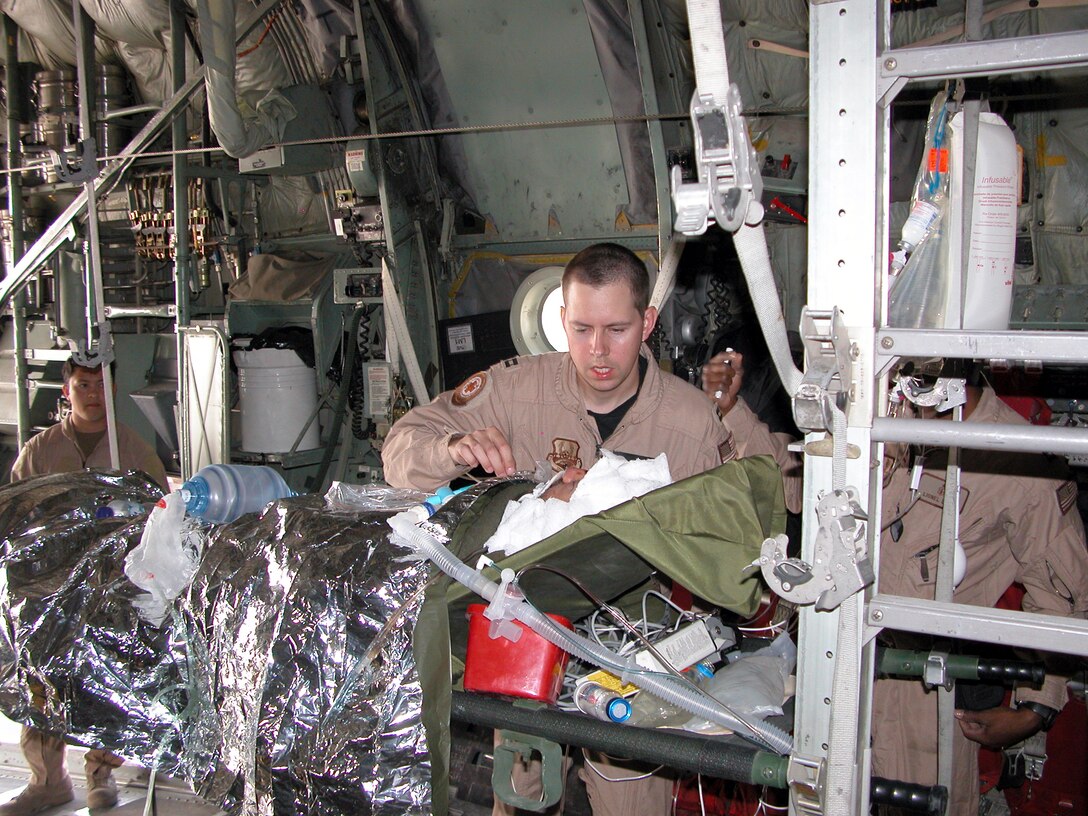 SOUTHWEST ASIA -- Capt. (Dr.) Erik von Rosenvinge conducts an initial assessment of his patient before a C-130 Hercules cargo aircraft leaves for Baghdad on Jan. 28.  The doctor is a 379th Aeromedical Squadron critical care air transport physician.  (U.S. Air Force photo by Tech. Sgt. Bob Oldham)