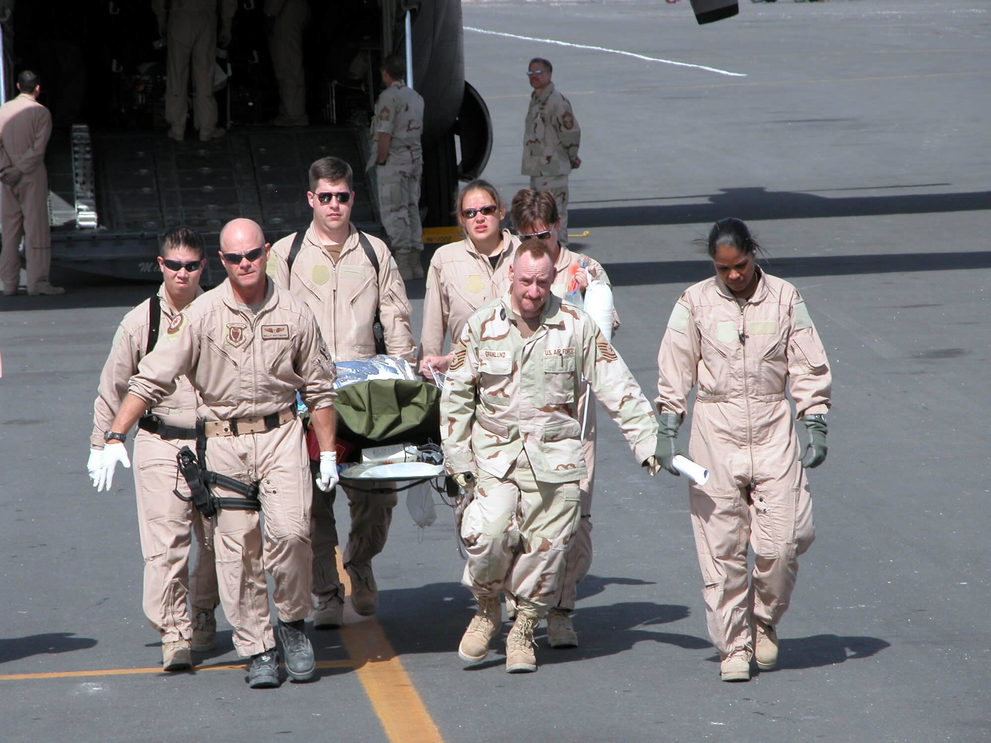 SOUTHWEST ASIA -- Medical workers and aircrew members transfer a patient from one C-130 Hercules to another that was waiting to take off.   The patient was transported to Baghdad on Jan. 28.  A critical care air transport team from the 379th Aeromedical Squadron managed the patient's care from Afghanistan to Baghdad.  (U.S. Air Force photo by Tech. Sgt. Bob Oldham)