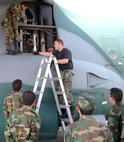 BOGOTA, Colombia -- While on a temporary assignment here, Tech. Sgt. Alwin Lopez (on ladder) explains general hydraulic principles and inspection techniques to Colombian military students.  Sergeant Lopez is a a C-130 Hercules crew chief from the 653rd Combat Logistics Support Squadron at Robins Air Force Base, Ga.  He is in Columbia supporting the Air Force Security Assistance Training Squadron program.  (Courtesy photo)