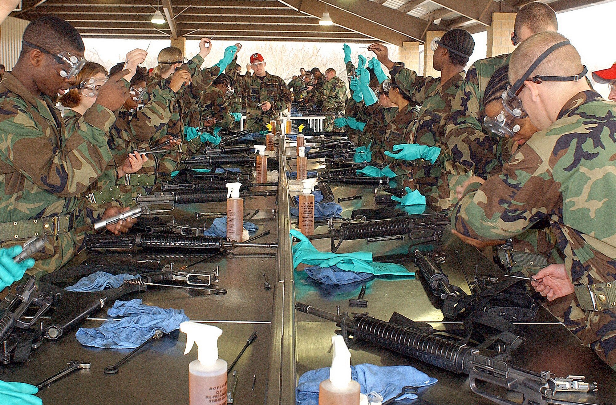 LACKLAND AIR FORCE BASE, Texas (AFPN) -- Basic trainees disassemble and clean M-16s recently at the newly opened weapons cleaning pavilion here.  (Courtesy photo)
