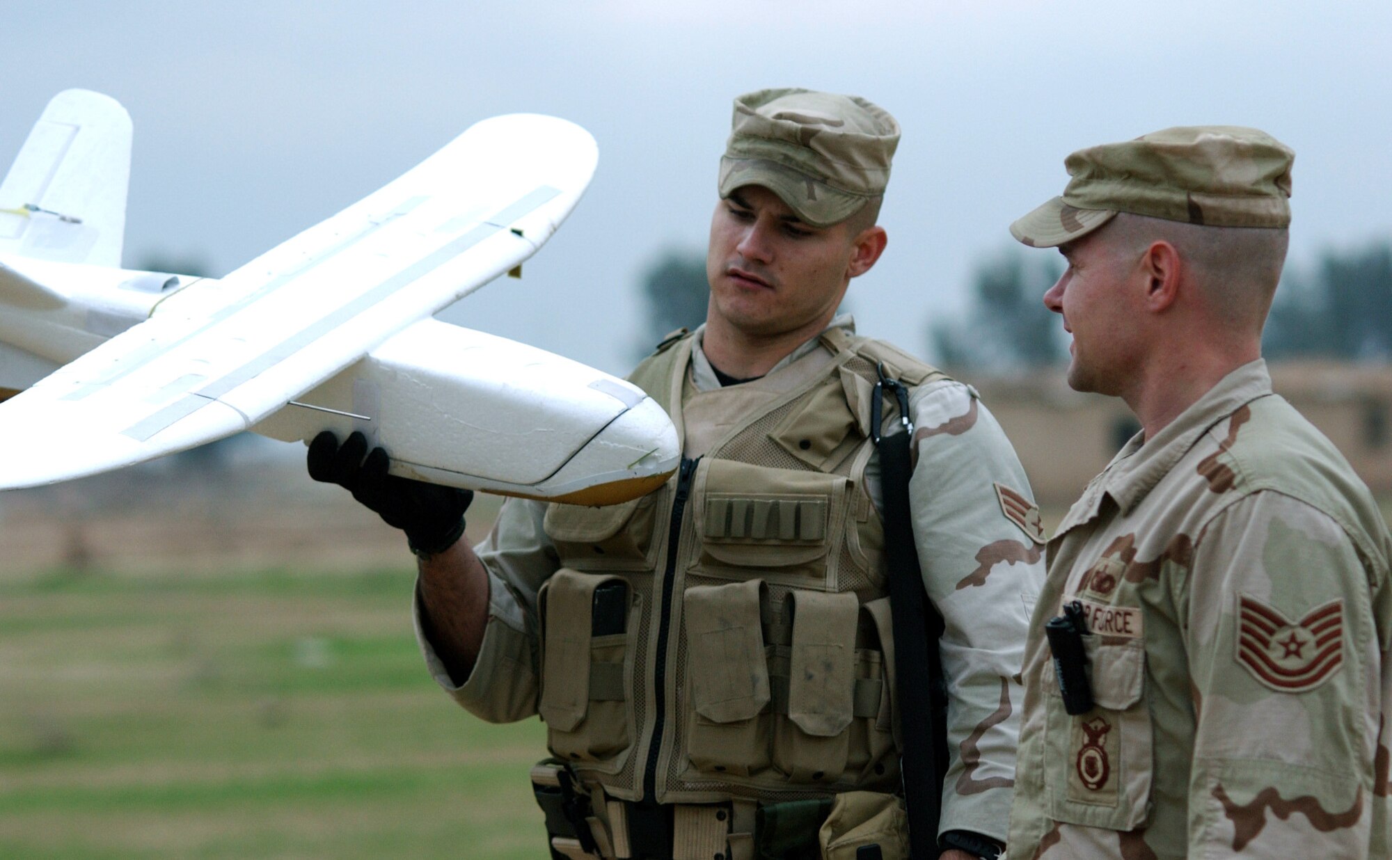 BALAD AIR BASE, Iraq (AFPN) -- Senior Airman David Tillery (left) and Tech. Sgt. Lloyd Joyner look over Desert Hawk after a mission.  The 7-pound unmanned aerial vehicle allows security forces to see beyond a base's perimeters and provide accurate, real-time visual assessments of detected threats.  Both airmen are assigned to the 332nd Expeditionary Security Forces Squadron and are deployed from Shaw Air Force Base, S.C.  (U.S. Air Force photo by Staff Sgt. A.C. Eggman)