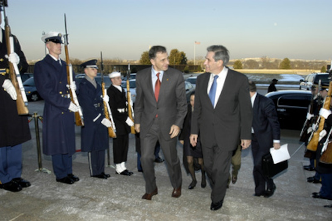 Romanian Minister of Foreign Affairs Mircea Geoana (left) talks with Deputy Secretary of Defense Paul Wolfowitz as they walk through an honor cordon and into the Pentagon on Feb. 4, 2004. The two men will hold talks on a range of bilateral security issues. 