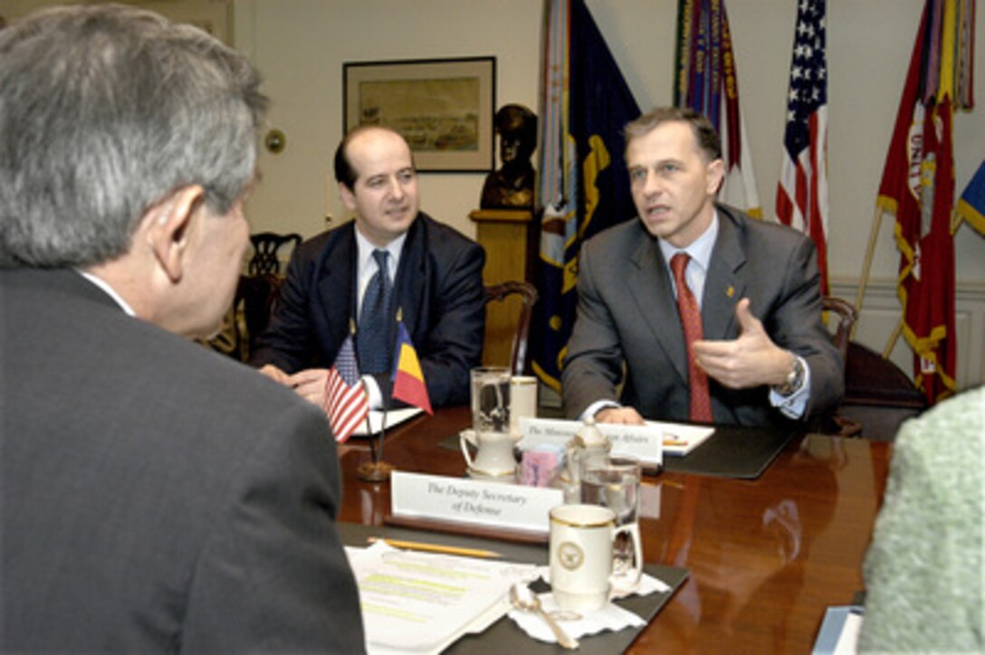 Romanian Minister of Foreign Affairs Mircea Geoana (right) meets with Deputy Secretary of Defense Paul Wolfowitz (foreground) in the Pentagon on Feb. 4, 2004. Under discussion is a broad range of bilateral security issues. Also participating in the talks is Romanian Ambassador to the United States Sorin Ducaru (center). 