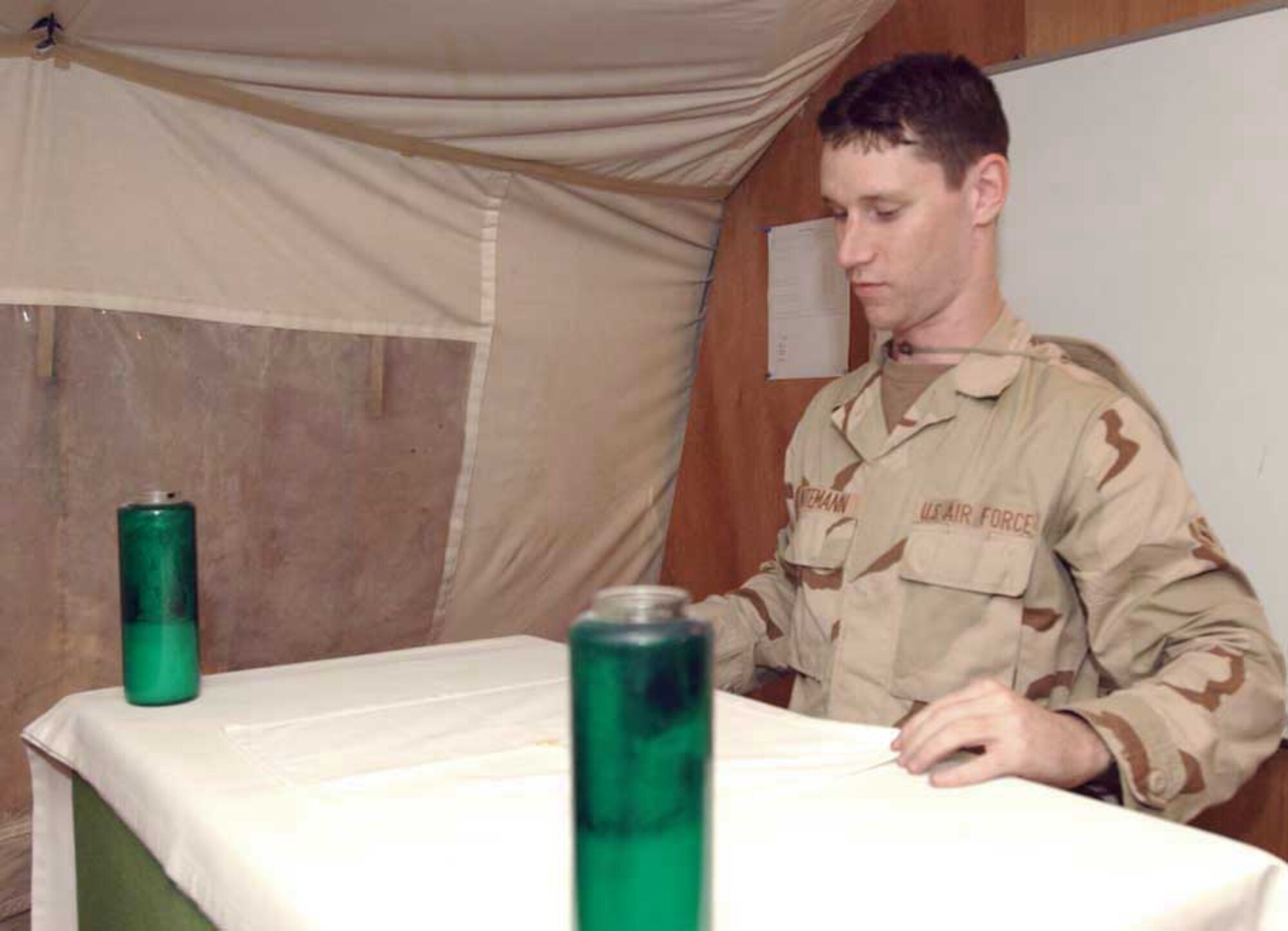 SOUTHWEST ASIA -- Airman Kevin Intemann, a chaplain assistant, sets up for a religious service.  Chaplain assistants take care of office functions and the logistical needs of the chapel so chaplains can concentrate on people in a deployed environment.  Airman Intemann is assigned to the 379th Air Expeditionary Wing.  (U.S. Air Force photo by Senior Airman Lakisha Croley)