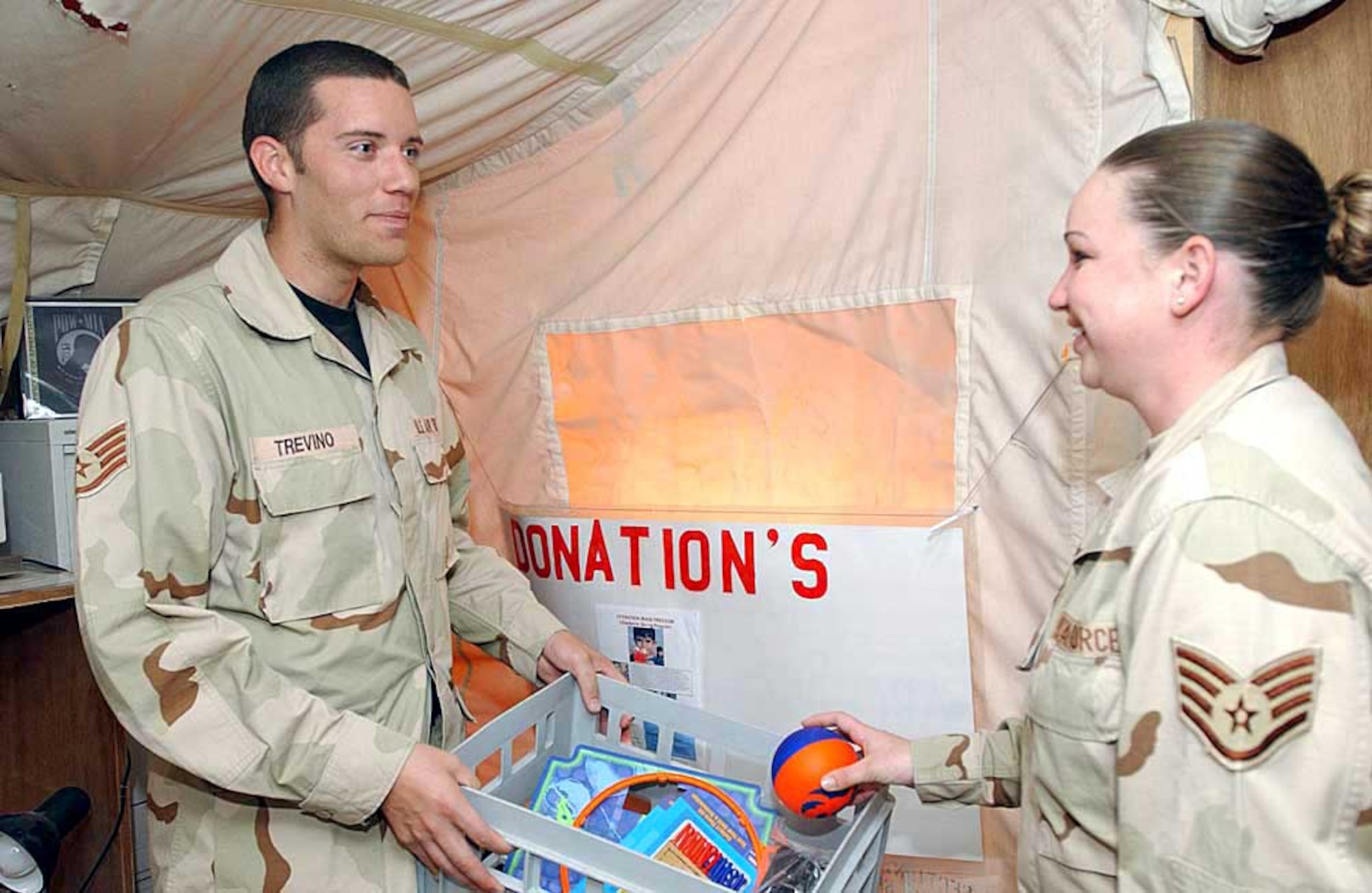 SOUTHWEST ASIA -- Staff Sgt. Benjamin Trevino, a chaplain assistant, collects a donation for children in Iraq and Afghanistan from Staff Sgt. Jessica Jones.  Chaplain assistants take care of office functions and the logistical needs of the chapel so chaplains can concentrate on people in a deployed environment.  Both sergeants are assigned to the 379th Air Expeditionary Wing.  (U.S. Air Force photo by Senior Airman Lakisha Croley)