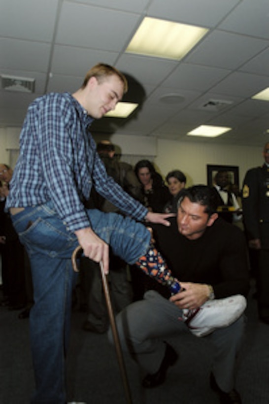 Army Sgt. Michael Cain has his prosthesis autographed by Ohio Valley Wrestling World Heavyweight Champion and World Tag Team Champion Deacon Batista during a luncheon in the Pentagon on Feb. 13, 2004. Cain is among the 30 guests hosted by Deputy Secretary of Defense Paul Wolfowitz from Walter Reed Army Medical Center recovering from wounds received in Iraq and Afghanistan. Batista will later travel to Walter Reed to meet with soldiers unable to attend the luncheon. 