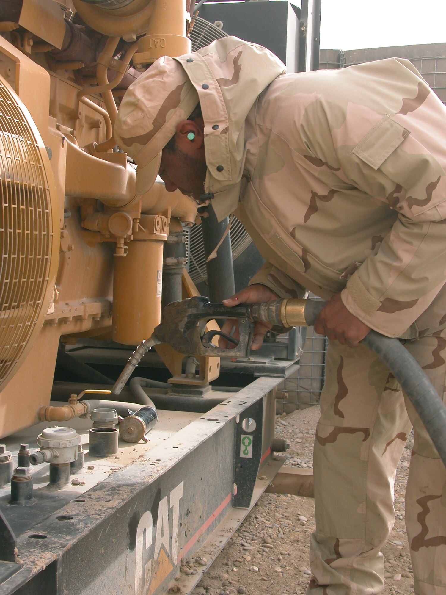 TALLIL AIR BASE, Iraq (AFPN) -- Senior Airman Romanuel Carter prepares to fill a generator with diesel fuel.  The 407th Expeditionary Logistics Readiness Squadron's fuels flight delivers to 42 routine fill points daily.  Airman Carter is a fuels distribution operator deployed here from Kadena Air Base, Japan.   (U.S. Air Force photo by Photo by Tech. Sgt. Bob Oldham)
