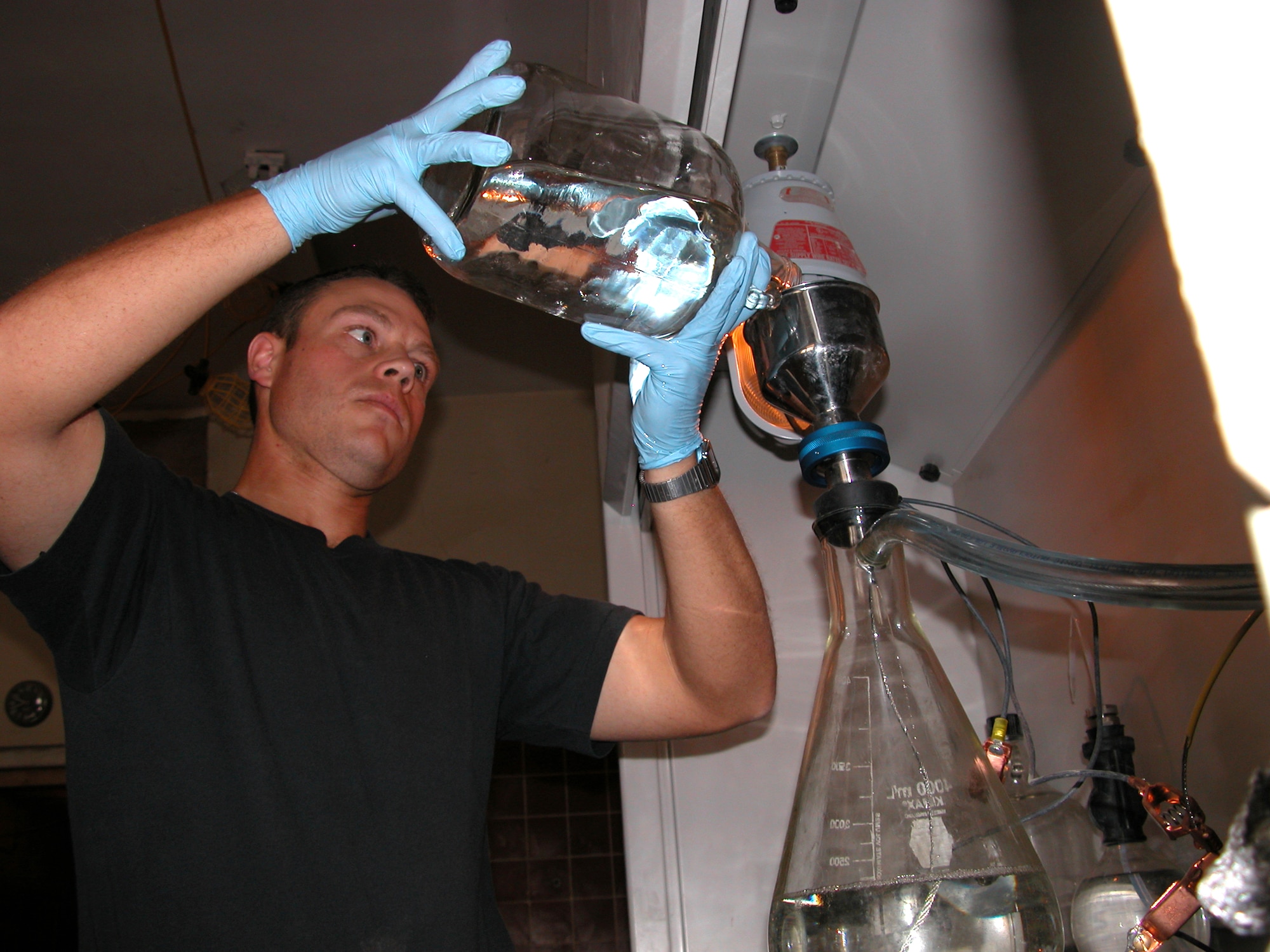 TALLIL AIR BASE, Iraq (AFPN) -- Senior Airman Kasey Saunders pours aviation fuel through a funnel to test the amount of solid matter in a fuel sample.  Before fuel can be loaded onto an aircraft, it must be tested and have less than 2 milligrams per gallon of solid matter.  Airman Saunders is deployed here from Kadena Air Base, Japan.  (U.S Air Force photo by Tech. Sgt. Bob Oldham)
