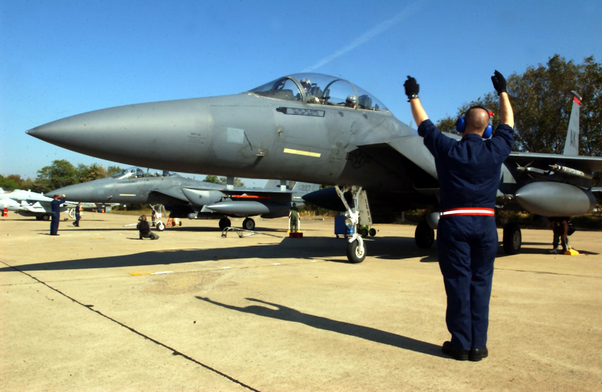 KORAT ROYAL THAI AIR FORCE BASE, Thailand (AFPN) -- A 3rd Aircraft Maintenance Squadron crew chief from Elmendorf Air Force Base, Alaska, guides an F-15E Strike Eagle from the 90th Fighter Squadron during exercise Cope Tiger '04 here.  The 90th FS, also from Elmendorf AFB, is providing 12 Strike Eagles for the annual exercise which runs through Feb. 27.  (U.S. Air Force photo by Tech. Sgt. Lee Harshman)