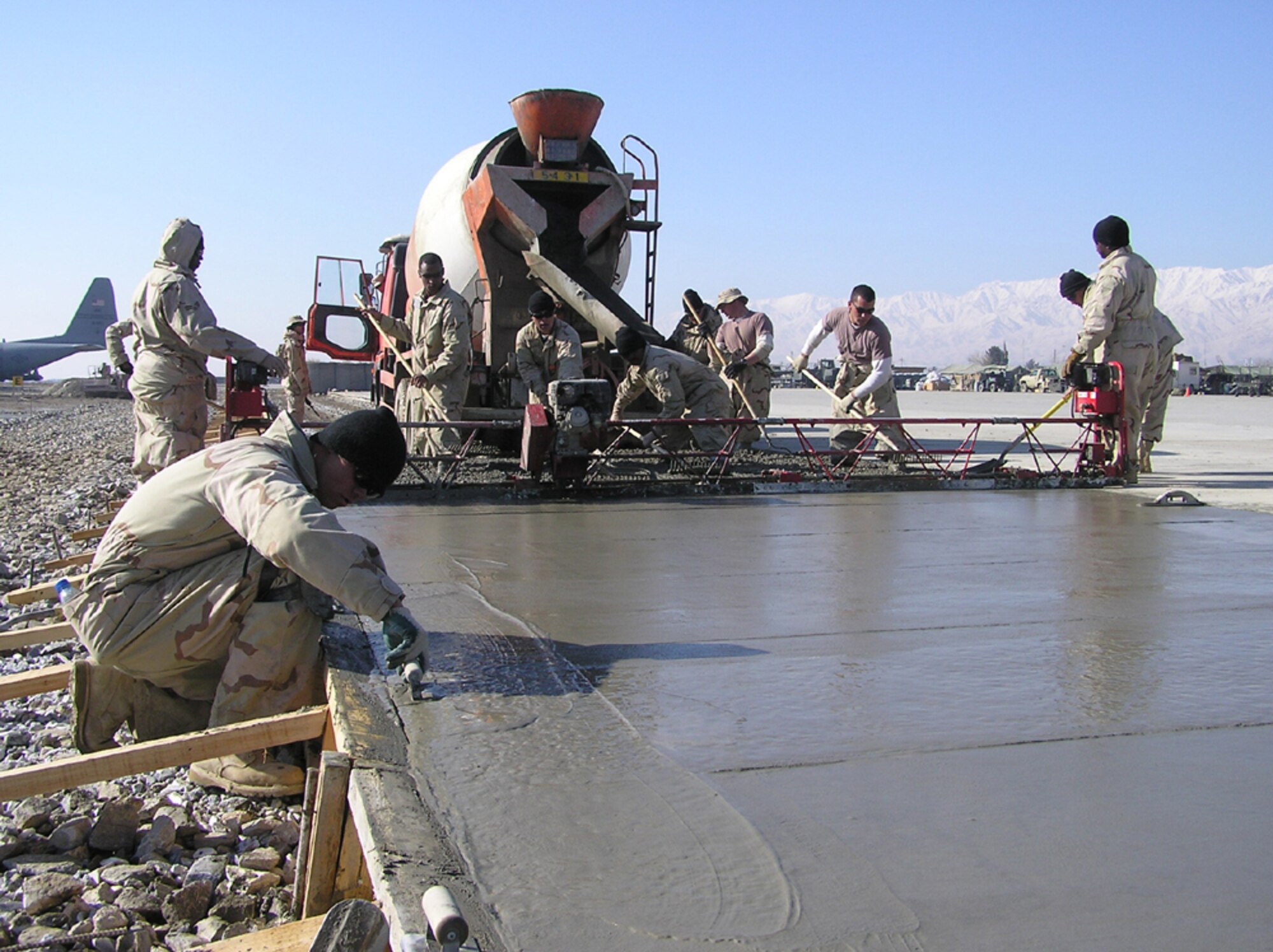 BAGRAM AIR BASE, Afghanistan -- Airmen with the 455th Expeditionary Civil Engineer Squadron spread concrete to expand the combat aircraft ramp here.  The airmen are deployed from Travis Air Force Base, Calif., and supporting Operation Enduring Freedom.  (U.S. Air Force photo by Tech. Sgt. Brian Davidson)