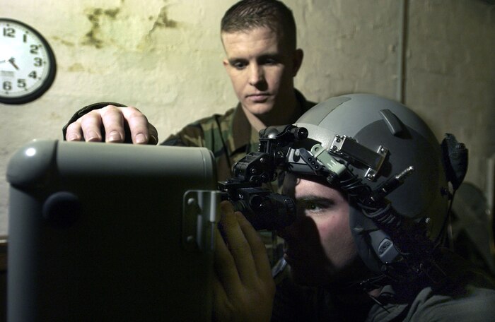 RHEIN-MAIN AIR BASE, Germany -- Senior Airman Luke Mailander helps Airman 1st Class Dan Carbon try his night-vision goggles during his preflight equipment check.  Airman Carbon is a C-17 Globemaster III loadmaster with the 817th Expeditionary Airlift Squadron and deployed from Charleston AFB, S.C.  Airman Mailander is an aircrew lift support technician with the 817th EAS and deployed from Travis Air Force Base, Calif.  (U.S. Air Force photo by Master Sgt. Keith Reed)
