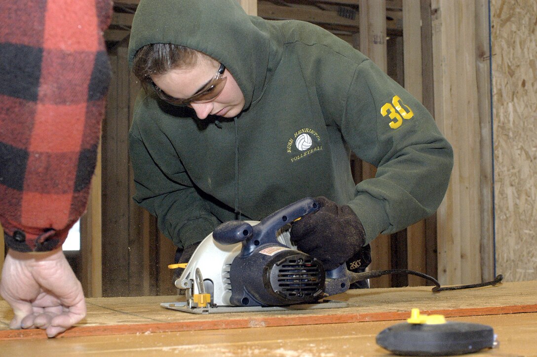 OGDEN, Utah -- Airman 1st Class Heather Mummery cuts plywood for the walls of a new Habitat for Humanity house airmen from nearby Hill Air Force Base are building.  Airman Mummery is a line delivery crew chief with the 388th Equipment Maintenance Squadron.  (U.S. Air Force photo by Senior Airman Nakita Carlisle)