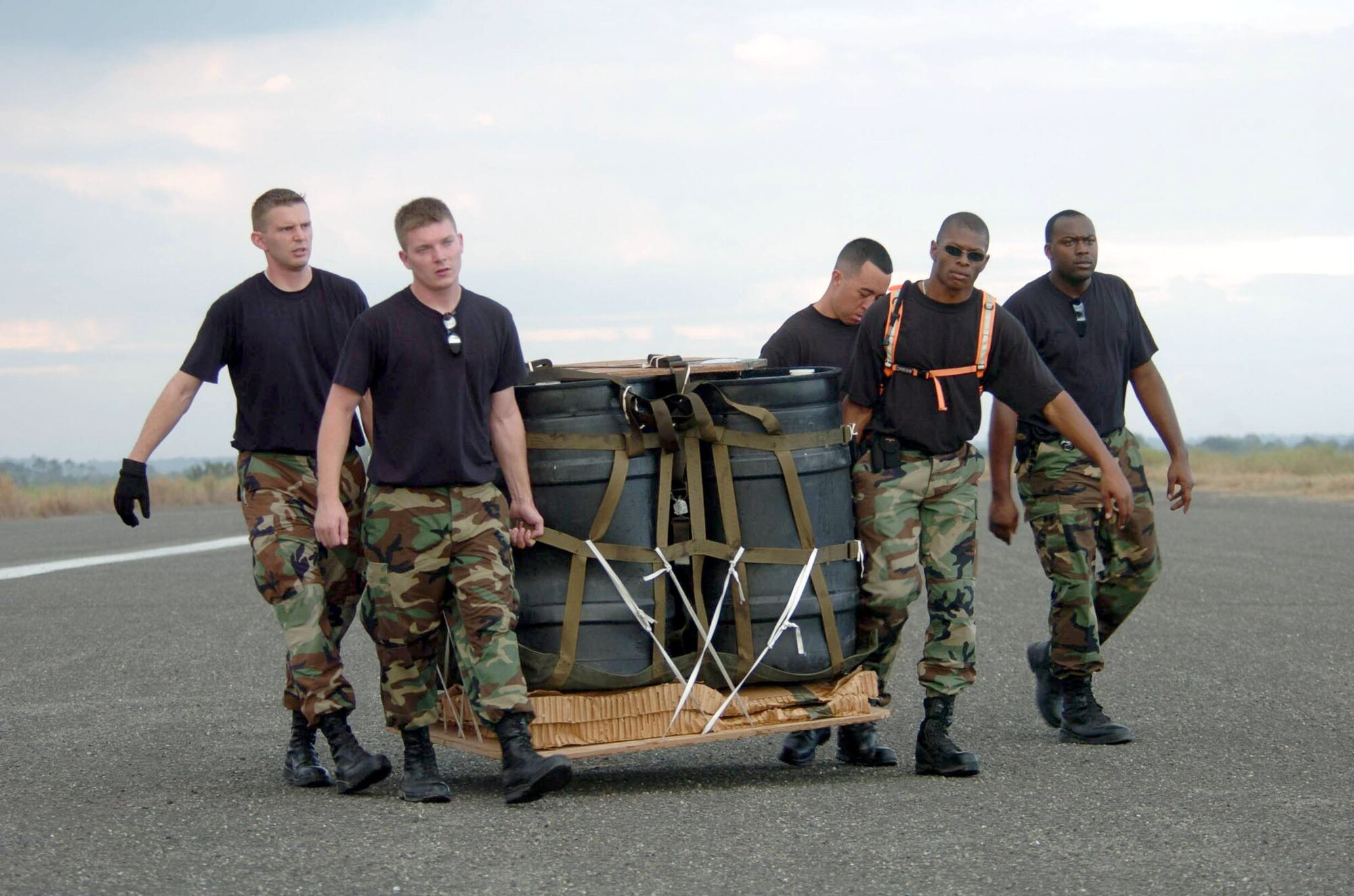 BASA AIR BASE, Philippines -- Airmen move a container delivery system after it landed at a drop zone during low-altitude airdrop training here Feb. 25 during Balikatan 2004.  The airmen are part of the 18th Logistics Readiness Squadron's combat mobility element from Kadena Air Base, Japan.  Balikatan is an annual bilateral exercise that demonstrates U.S. resolve and commitment to train, advise and assist the Philippine government.  (U.S. Air Force photo by Master Sgt. Val Gempis)