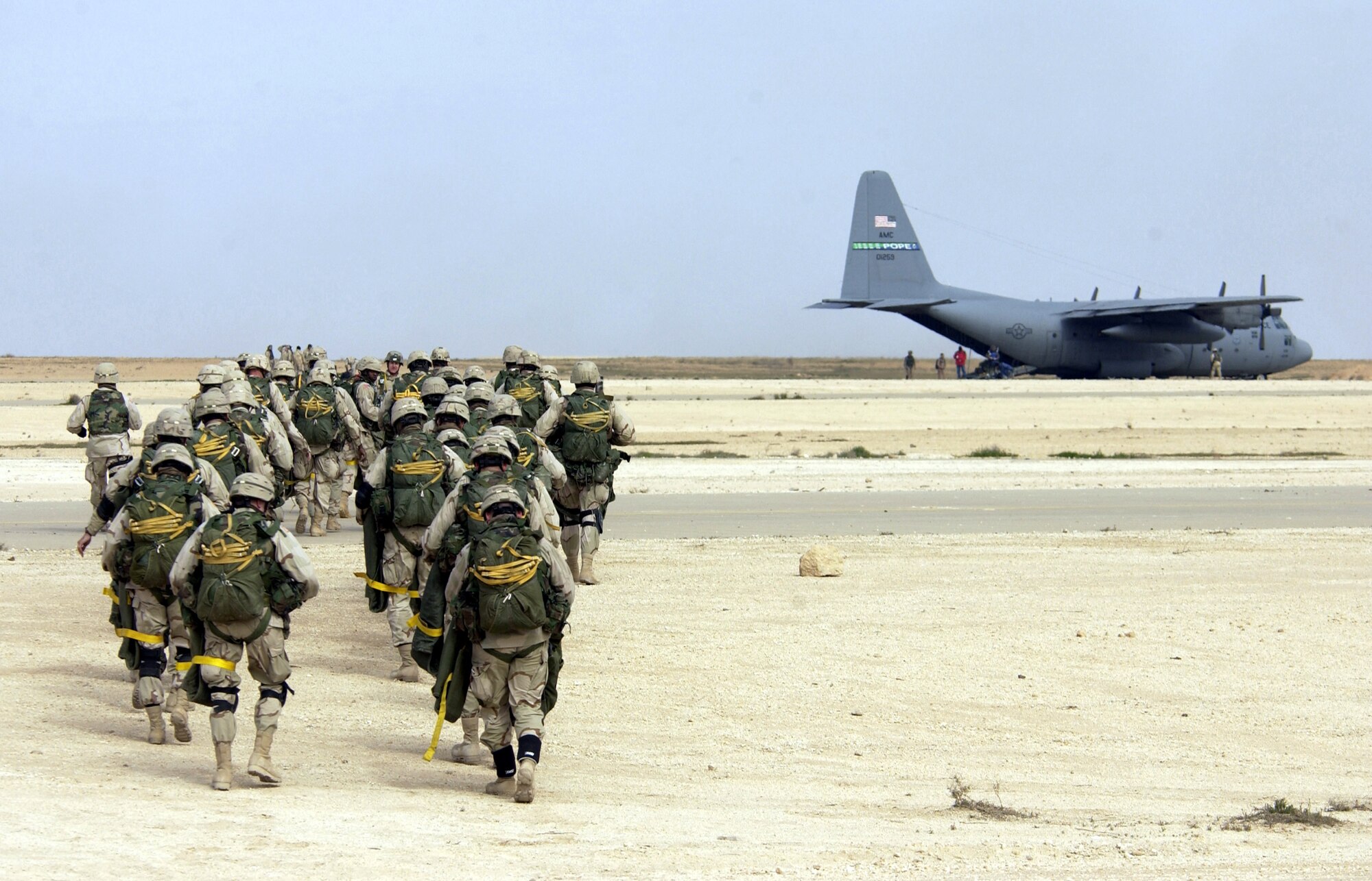 SOUTHWEST ASIA -- Soldiers from the 82nd Airborne Division head toward a C-130 Hercules as part of Operation All-American Lightning on Feb. 24.  A total of 240 soldiers conducted airdrop training during a capabilities and show-of-force exercise.  Before the start of the parachute jumps, A-10 Thunderbolt IIs conducted missile and strafing runs, and F-16 Fighting Falcons dropped 12 bombs on a simulated target near the airfield as part of the exercise.  (U.S. Air Force photo by Staff Sgt. Suzanne Jenkins)