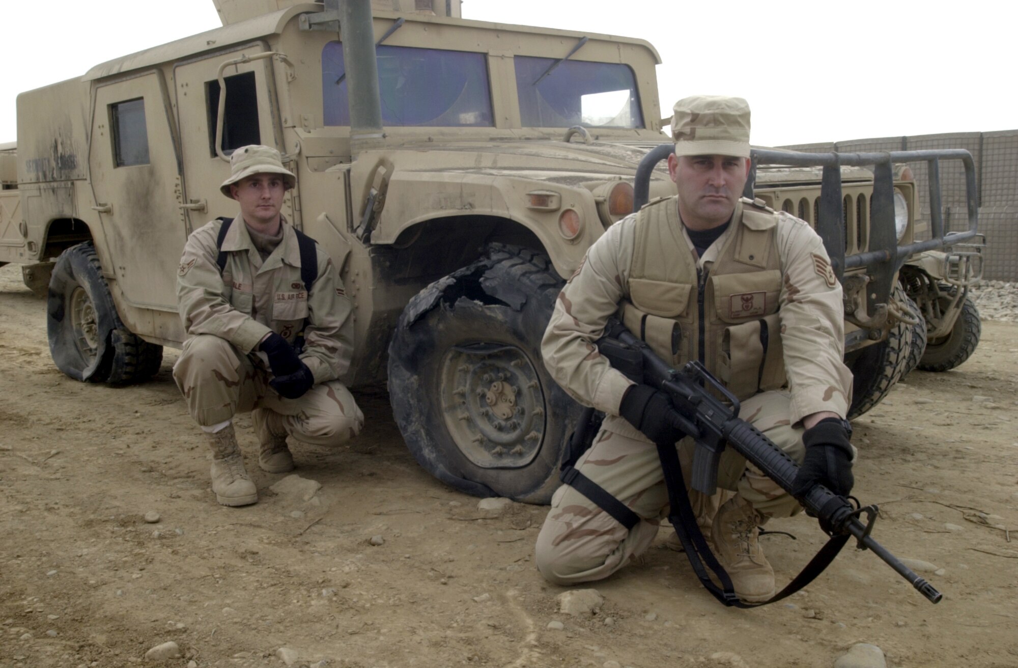 BAGRAM AIR BASE, Afghanistan -- Staff Sgt. Michael Klinkert (right) and Airman 1st Class Christopher Coble were driving this heavily armored Humvee at about 8 p.m. Jan. 5 when they entered an unmarked minefield here.  Explosions rocked the vehicle and they were stranded for about two hours until a mine-clearing vehicle was sent in.  Sergeant Klinkert and Airman Coble are security forces specialists assigned to the 455th Expeditionary Operations Group here.  Both are deployed from Holloman Air Force Base, N.M.  (U.S. Air Force photo by Tech. Sgt. Brian Davidson)