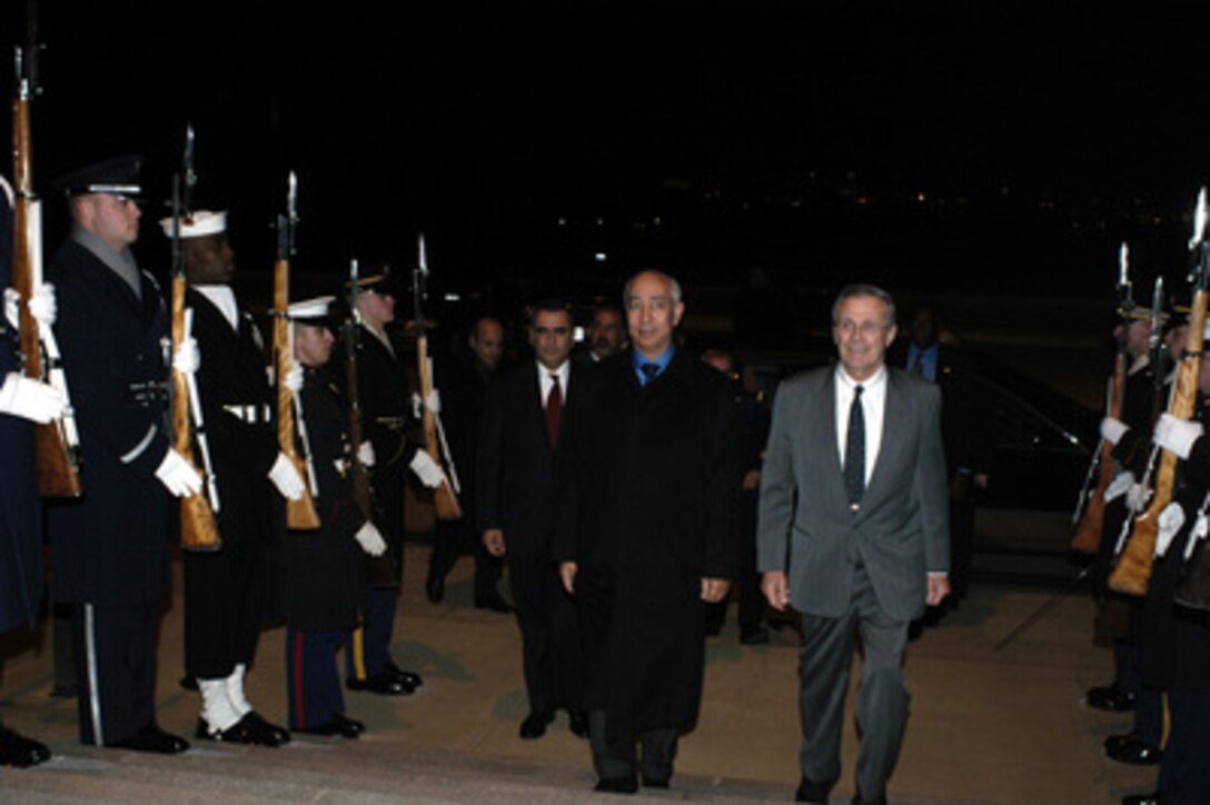 Secretary of Defense Donald H. Rumsfeld escorts Prime Minister Driss Jettou of the Kingdom of Morocco through a cordon and into the Pentagon on Jan. 8, 2004. The two leaders are meeting to discuss defense issues of mutual interest. 