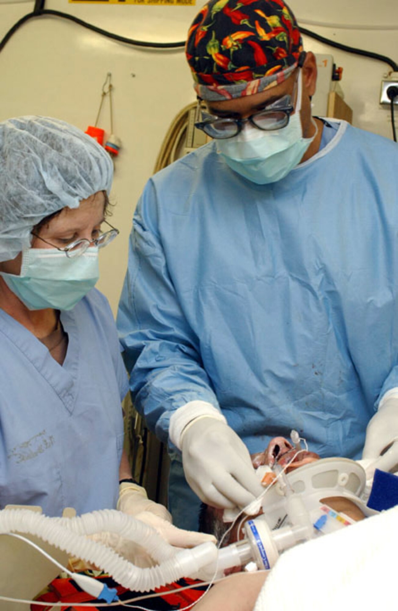 TALLIL AIR BASE, Iraq -- Maj. (Dr.) Donovan Tapper (right) and Maj. Bonnie Mack dress the wounds of a burn vicitim Jan 9.  Three patients were transported to the medical facility here for emergency treatment after they were involved in an off-base vehicle accident.  Dr. Tapper and Major Mack are assigned to the base's 332nd Expeditionary Medical Group.  (U.S. Air Force photo by Staff Sgt. C E Lewis)