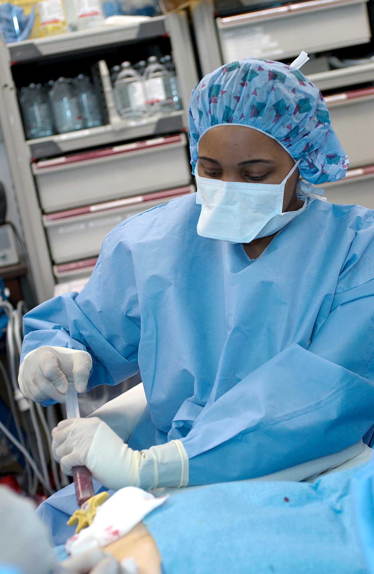 WASHINGTON -- Dr. Tamarro Taylor performs the harvest procedure to extract marrow from Capt. Brent Davis' pelvic bone.  The marrow Captain Davis donated will aid a 17-year-old boy in his recovery from non-Hodgkin's lymphoma, a type of cancer.  Dr. Taylor is an assistant professor of medicine at Georgetown University.  Captain Davis is the 910th Airlift Wing public affairs chief at Youngstown Air Reserve Station, Ohio.  (U.S. Air Force photo by Master Sgt. Jim Varhegyi)