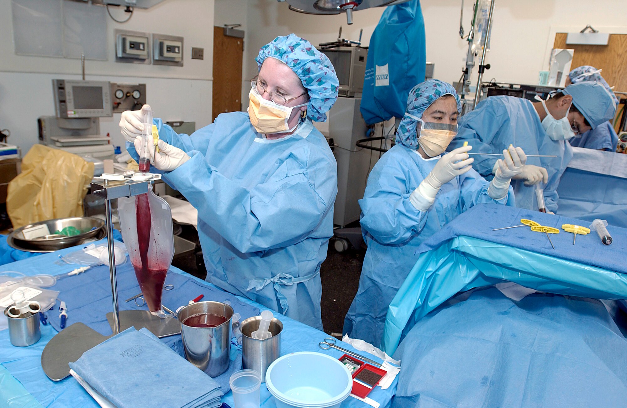 WASHINGTON -- While one medical worker filters Capt. Brent Davis's marrow into a special collection bag, others prepare needles and continues to withdraw marrow to make the procedure as quick as possible.  The marrow Captain Davis donated will aid a 17-year-old boy in his recovery from non-Hodgkin's lymphoma, a type of cancer.  Captain Davis is the 910th Airlift Wing public affairs chief at Youngstown Air Reserve Station, Ohio.  (U.S. Air Force photo by Master Sgt. Jim Varhegyi)