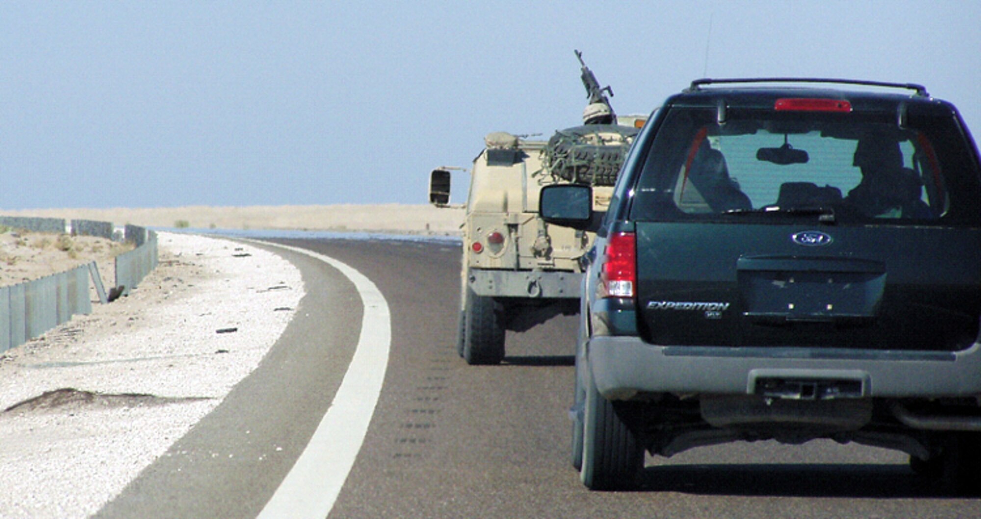 IRAQ -- A convoy vehicle is led by armed forces through Iraq so deployed contractors from Elmendorf Air Force Base, Alaska, can buy supplies.  (U.S. Air Force photo by Tech. Sgt. Jamie Dufrene)