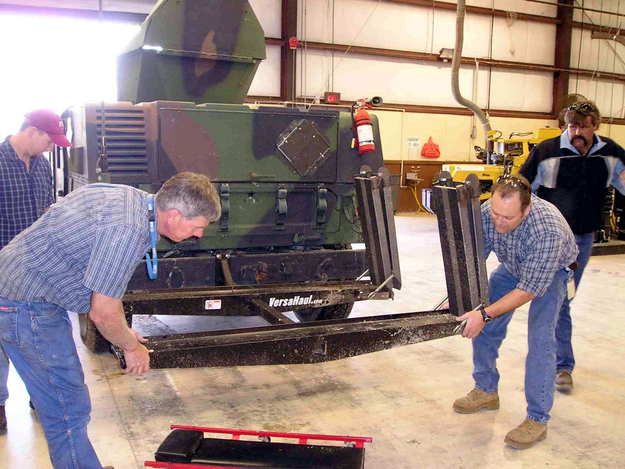 TYNDALL AIR FORCE BASE, Fla. -- Al Hartzog (left) and Darrell Stepp position the modified bumper mount on an armored Humvee similar to the ones used in Operation Iraqi Freedom.  Both men work at the materials and manufacturing directorate's force protection branch here.  (Courtesy photo)