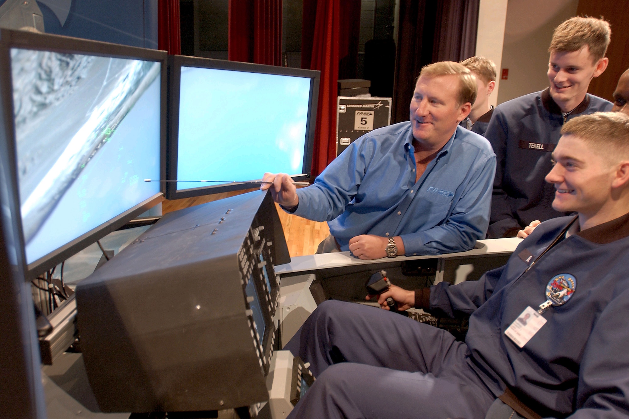 U.S. AIR FORCE ACADEMY, Colo. -- Cadet 3rd Class Robert Kurpiel (foreground) tests the F/A-22 Raptor's lethality by engaging four aerial targets using the Lockheed Martin F/A-22 flight simulator Jan. 8.  Academy cadets and staff got the opportunity to enjoy the flight simulator and talk with F/A-22 test pilots and program workers. (Altered U.S. Air Force photo by Joel Strayer)