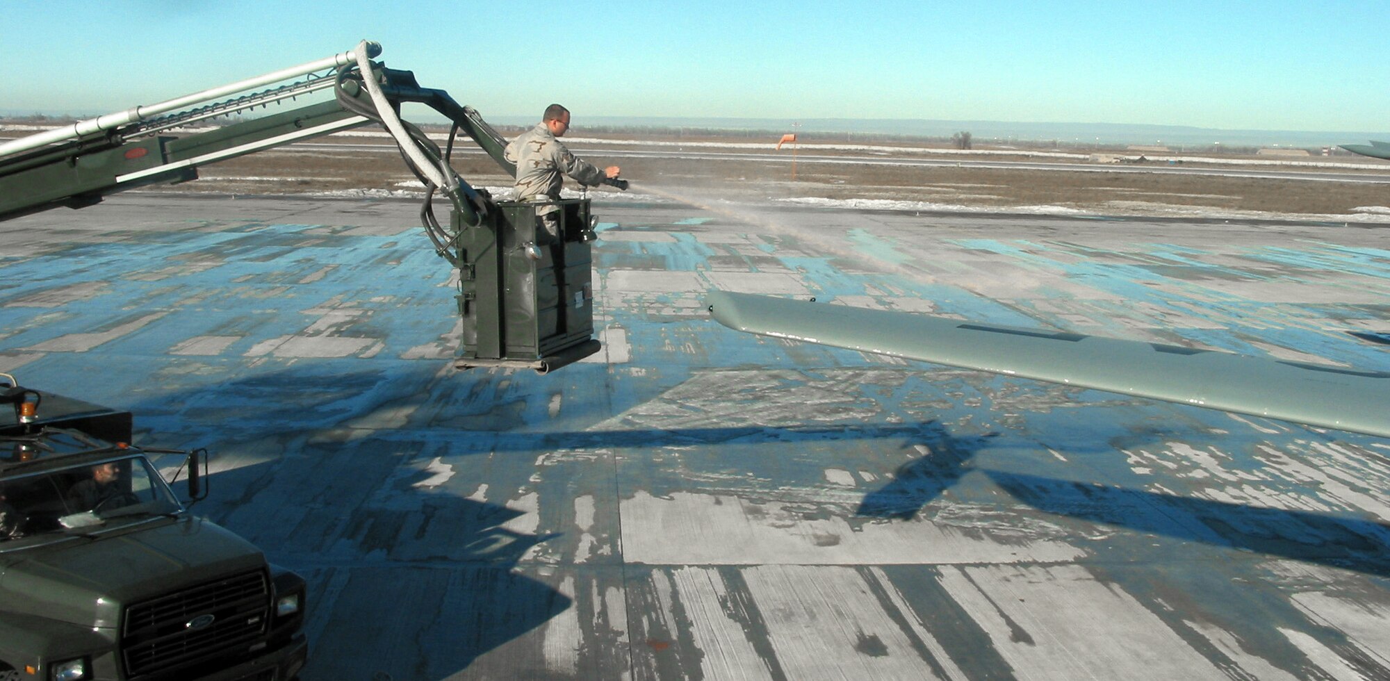 MANAS AIR BASE, Kyrgyzstan -- Staff Sgt. Christopher Smith de-ices an aircraft on the flightline here.  He is assigned to the 376th Air Expeditionary Wing's transient alert team.  (U.S. Air Force photo by Capt. Brus E. Vidal)