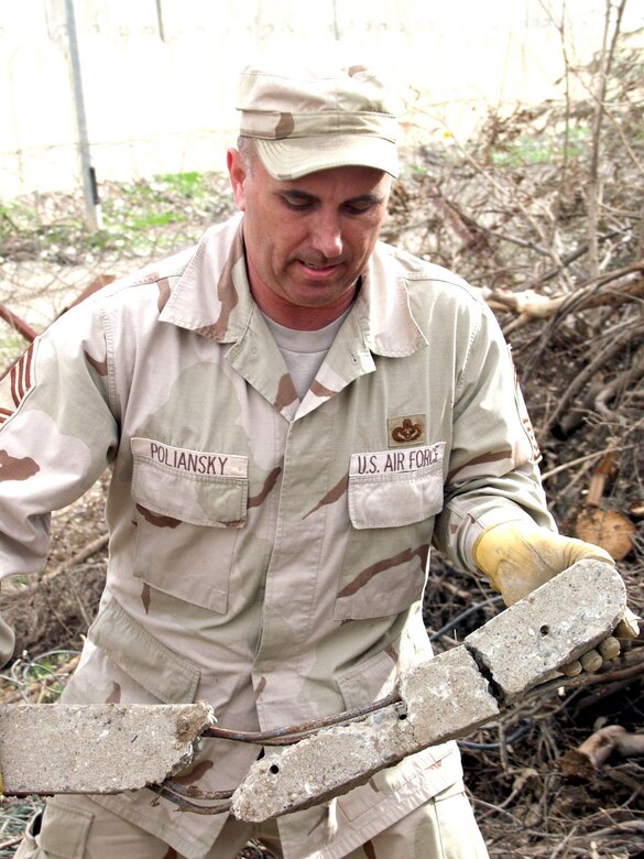 KIRKUK AIR BASE, Iraq -- Chief Master Sgt. Walter Poliansky removes part of a concrete pillar during the Jan. 11 cleanup effort to help restore a mosque here.  Chief Poliansky is chief of operations for the 506th Expeditionary Civil Engineer Squadron here.  (U.S. Air Force photo by Tech. Sgt. Jeffrey Williams)