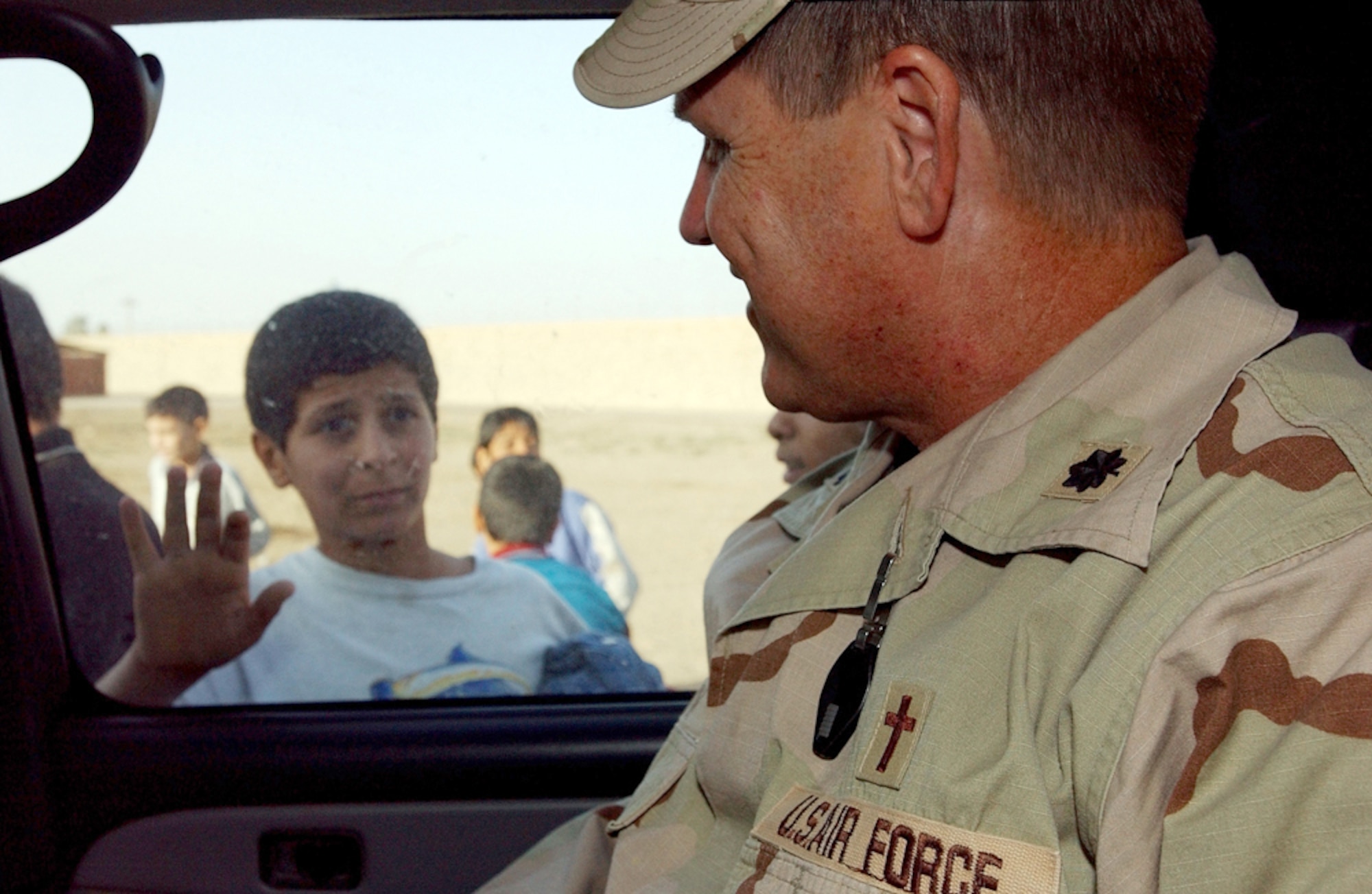 SOUTHWEST ASIA (AFPN) -- An Iraqi boy waves goodbye to Chaplain (Lt. Col.) Steven Keith after he delivered clothing, food and other items donated by airmen at Baghdad International Airport, Iraq.  Chaplain Keith is assigned to the 447th Air Expeditionary Group.  (U.S. Air Force photo by Tech. Sgt. Lisa Zunzanyika)