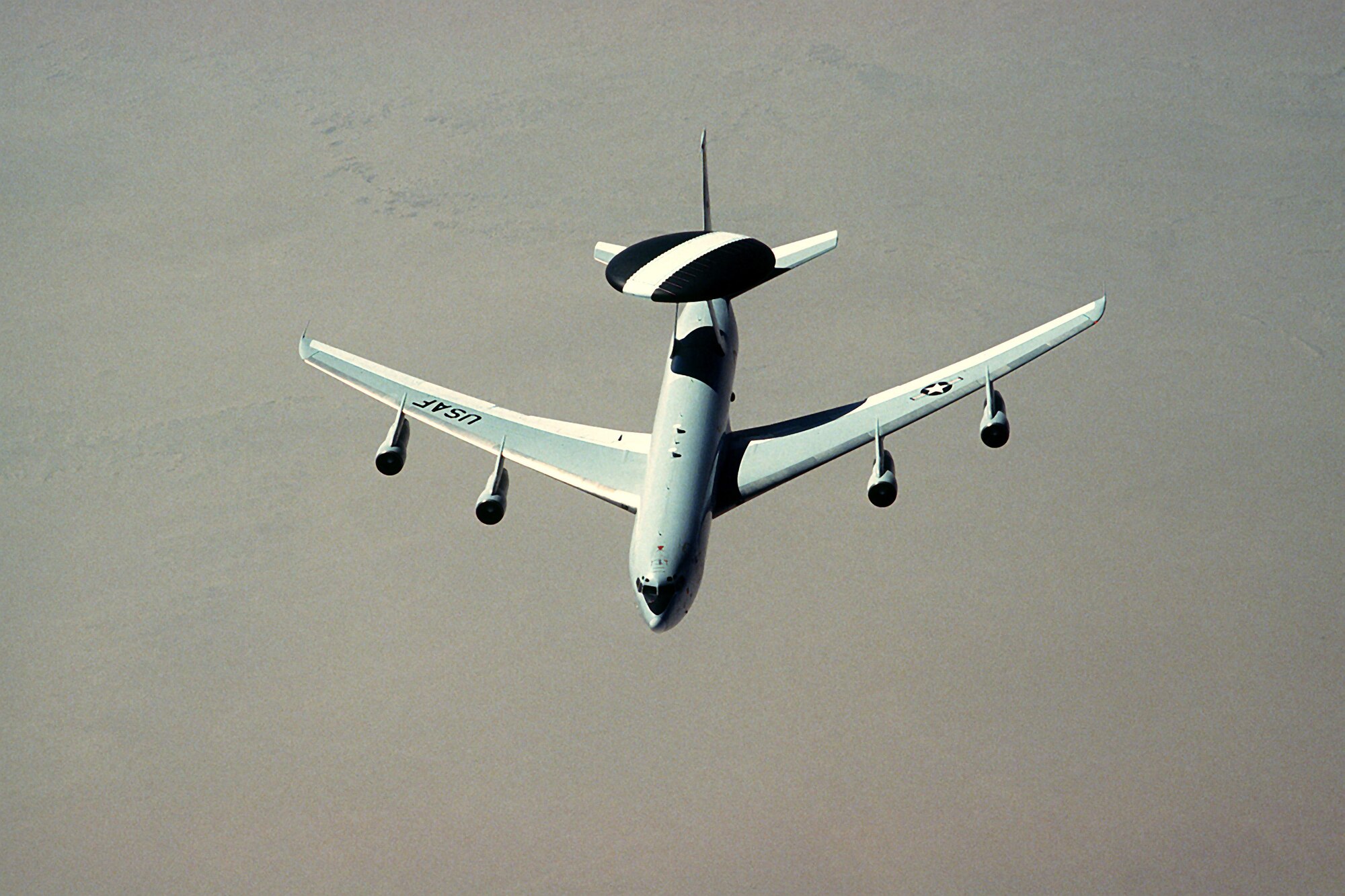 1990's -- An E-3 Sentry aircraft flies over the desert during Operation Desert Shield.