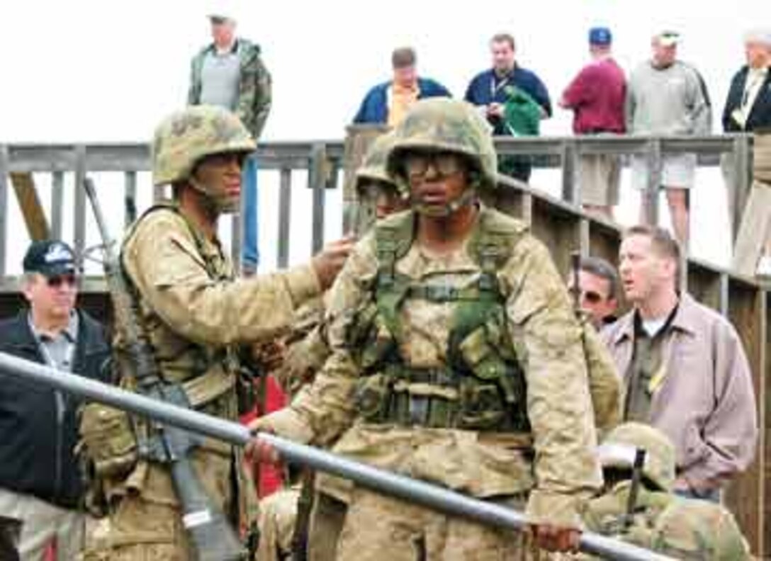 Lansing educators lookon as recruits negotiate obstacles during Lansing?s 2004 workshop. Each year, more than 300 educators from the 9th Marine Corps District travel to a recruit depot and learn more about the Corps.