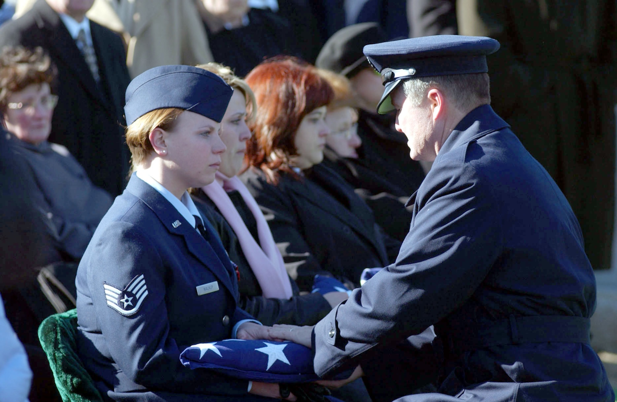 ARLINGTON, Va. -- Chief Master Sgt. of the Air Force Gerald R. Murray presents a flag to Staff Sgt. Carrissa Walkup during a full-honor mass funeral at Arlington National Cemetery.  Her husband, Staff Sgt. Thomas A. Walkup Jr., and four other military members were killed when their MH-53M Pave Low helicopter crashed Nov. 23 in Afghanistan. (U.S. Air Force photo by Staff Sgt. Jennifer Gangemi)