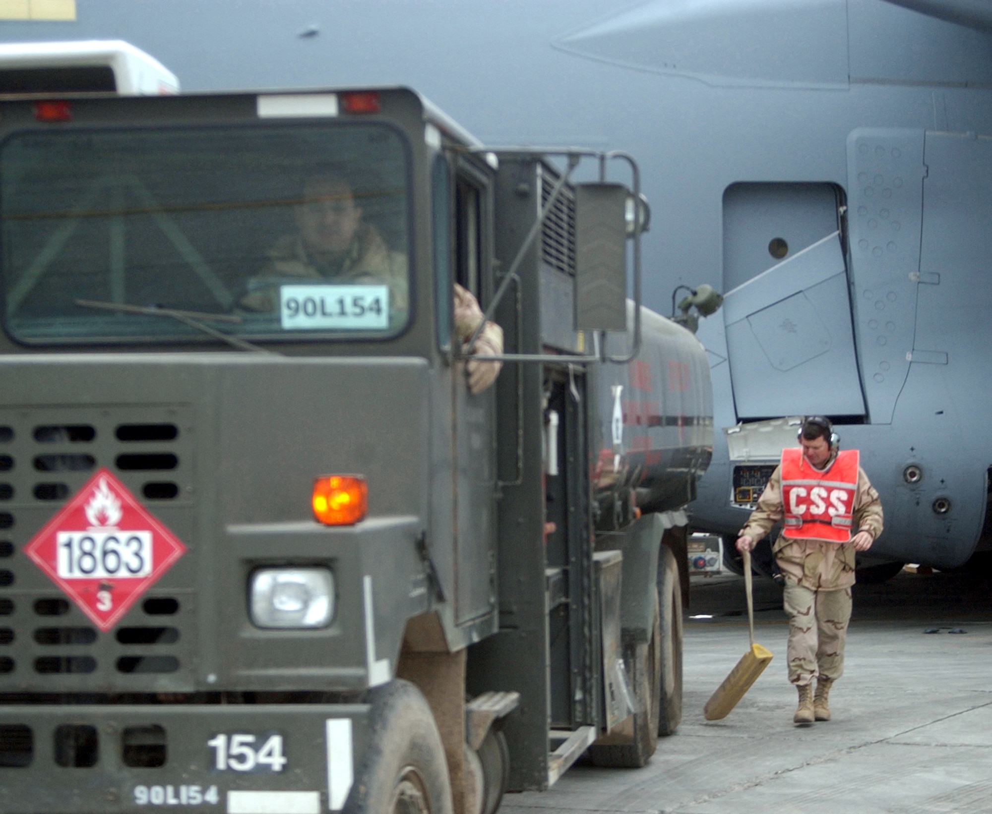 KARSHI-KHANABAD AIRFIELD, Uzbekistan -- Senior Master Sgt. Terry Gazaway (right) prepares to guide Master Sgt. Tom Guerrero as he backs a fuel truck toward a visiting C-17 Globemaster III here. Sergeant Gazaway is a transient alert superintendent and Sergeant Guerrero is a fuels superintendent.  Both are assigned to the 416th Expeditionary Operations Group.  (U.S. Air Force photo by Tech. Sgt. Brian Davidson)