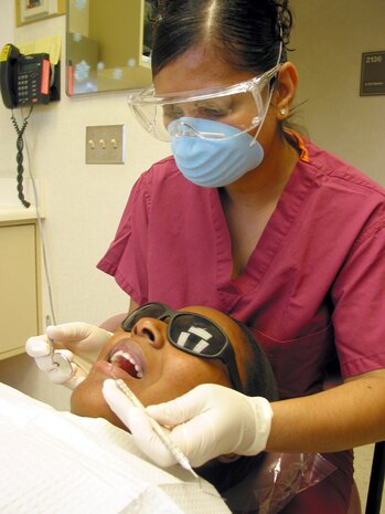 CHARLESTON AIR FORCE BASE, S.C. -- Tech. Sgt. Alycia Miller, a dental technician from Sheppard Air Force Base, Texas, cleans a patient's teeth.  Sergeant Miller is enrolled in an Air Force-sponsored dental hygiene training scholarship program at Trident Technician College in Charleston, S.C.  (U.S. Air Force photo by Airman 1st Class Amy Perry)