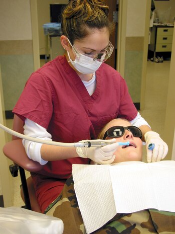 CHARLESTON AIR FORCE BASE, S.C. -- Staff Sgt. Noreena Svoboda, a dental technician from McChord Air Force Base, Wash., cleans a patient's teeth.  Sergeant Svoboda is enrolled in an Air Force-sponsored dental hygiene training scholarship program at Trident Technician College in Charleston, S.C.  (U.S. Air Force photo by Airman 1st Class Amy Perry)