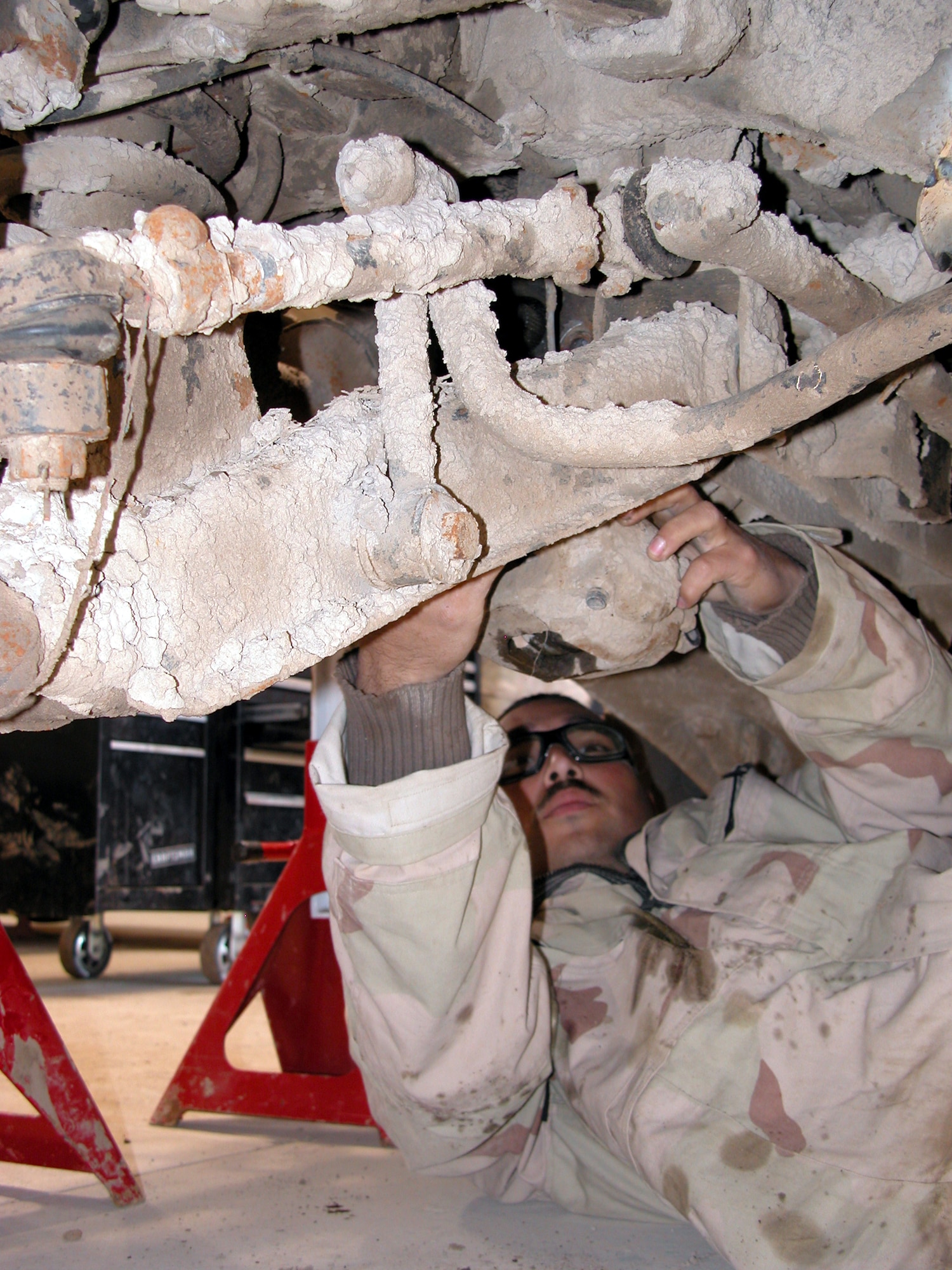 TALLIL AIR BASE, Iraq -- Senior Airman Juan Hurtado removes a caliper from a Humvee on Jan. 22.  Airman Hurtado is a vehicle mechanic with the 332nd Expeditionary Logistics Readiness Squadron and is deployed from Holloman Air Force Base, N.M.  (U.S. Air Force photo by Tech. Sgt. Bob Oldham)