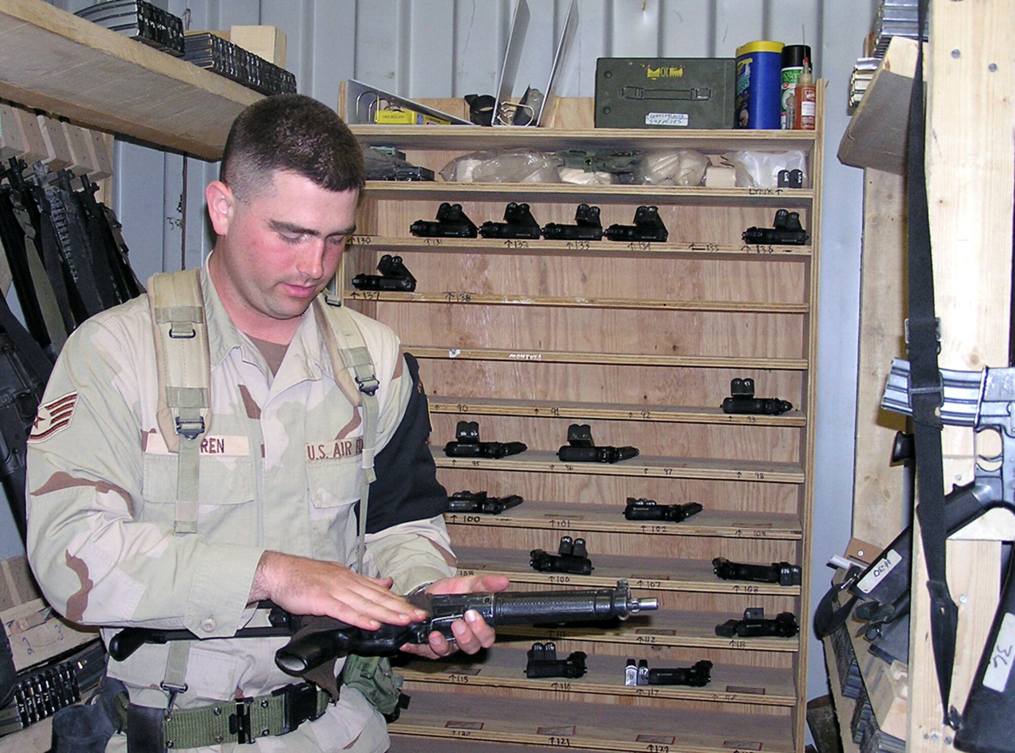 KIRKUK AIR BASE, Iraq -- Staff Sgt. Jerry Warren cleans off an MP-5 submachine gun before storing it in the escort armory here.  The armory stores almost 200 weapons for escorts and other security personnel.  Sergeant Warren is assigned to the 506th Air Expeditionary Group's escort flight and is deployed from Lackland Air Force Base, Texas.  (U.S. Air Force photo by Senior Master Sgt. Gene LaDoucer)