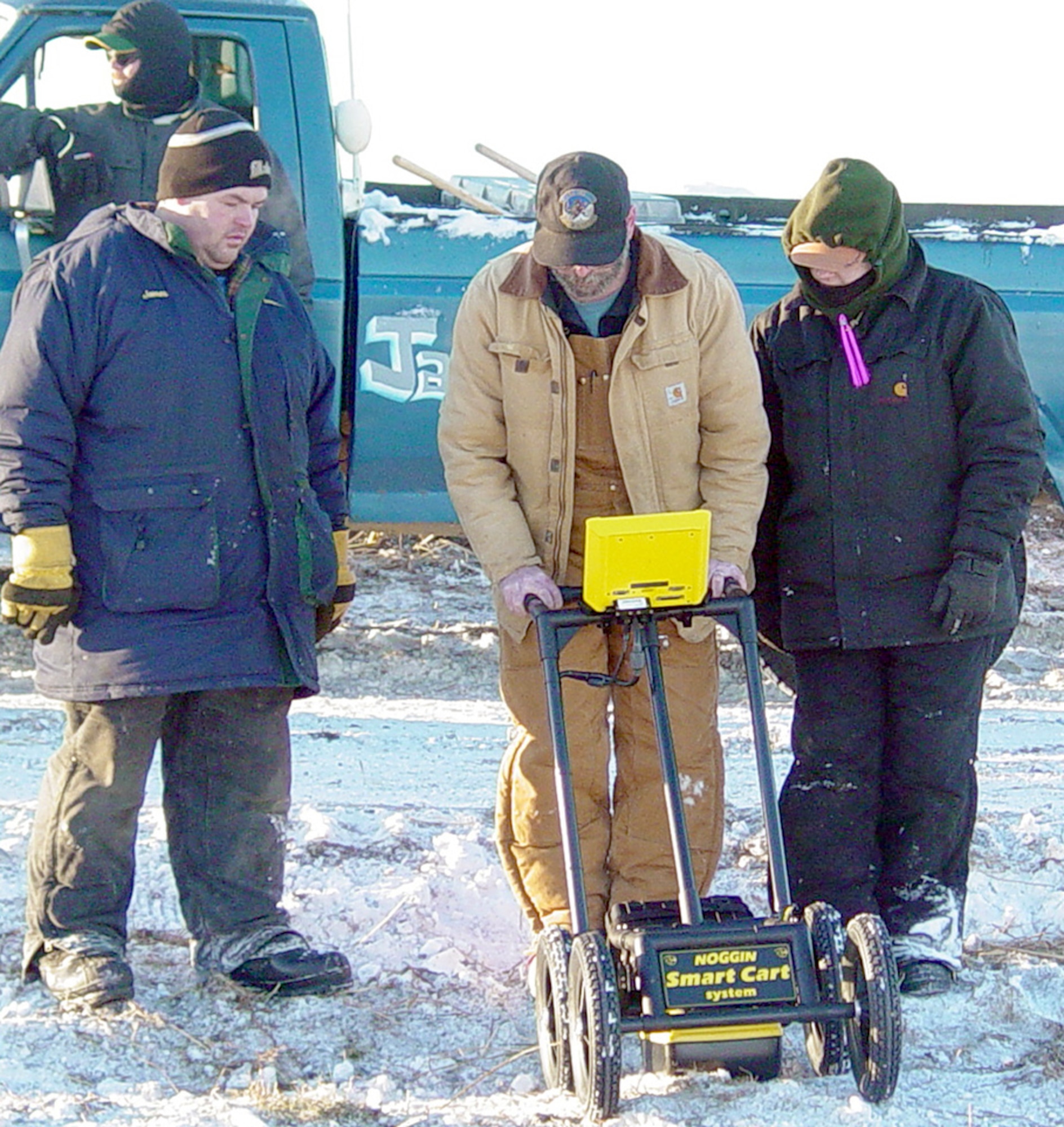 PORT HEIDEN, Alaska -- Tom Donley reads the screen on the ground-penetrating radar as Annie Clinton (right), a forensic anthropologist, observes.  Local resident Jimmy Christensen (left), like many residents, was interested in how the Air Force went about finding unmarked grave sites.  Mr. Donley is assigned to the 611th Civil Engineer Squadron's environmental flight.  (U.S. Air Force photo by 1st. Lt. KayLynn Meeker)