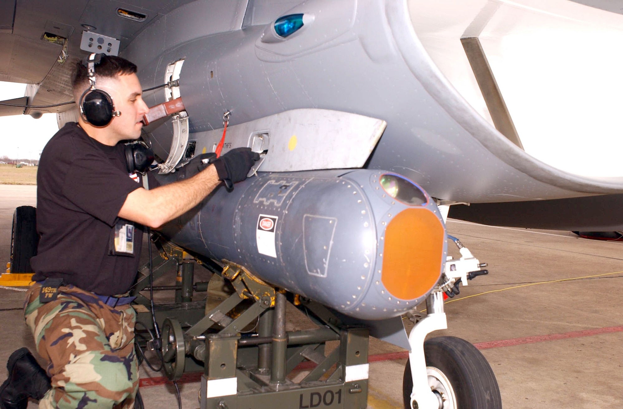 LACKLAND AIR FORCE BASE, Texas -- Tech. Sgt. Marcos Farias attaches a Low-Altitude Navigation and Targeting Infrared for Night targeting pod to a 149th Fighter Wing F-16 Fighting Falcon here.  The 149th FW will be the first unit in the Air Force to graduate pilots from the F-16 basic course with targeting-pod training.  (U.S. Air Force photo by Senior Master Sgt. Mike Arellano)